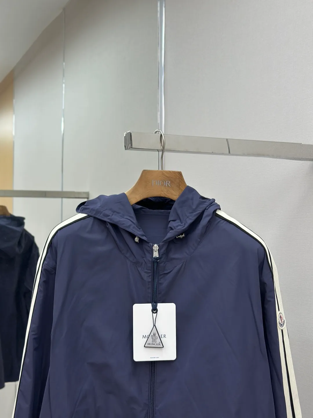 P560 MONCLER web-trimmed lightweight jacket Fabric selection: 100% polyester fiber is used to create a tough protective outer layer. It is known for its excellent tear resistance and wear resistance. It can quickly return to flatness during wearing and maintain the crisp and stylish appearance of the clothing for a long time. At the same time, it is not easy to deform after being washed for a long time.   Features: Two different colored decorative strips added to the center part of the sleeves. This design element can not only add visual highlights to clothing, making it more fashionable and unique. Craftsmanship: The webbing is precisely positioned along the cuffs to the seam of the collar and hat to ensure symmetry and overall smoothness. Before actual sewing, use very fine basting stitches for pre-fixing. This step is crucial to prevent the webbing from slipping, twisting, or wrinkling during sewing and ensuring that the final stitch is straight and perfect.  Accessories: Custom zipper puller, custom buttons with logo, custom hood drawstring elastic buckle SIZE: 1 2 3 4