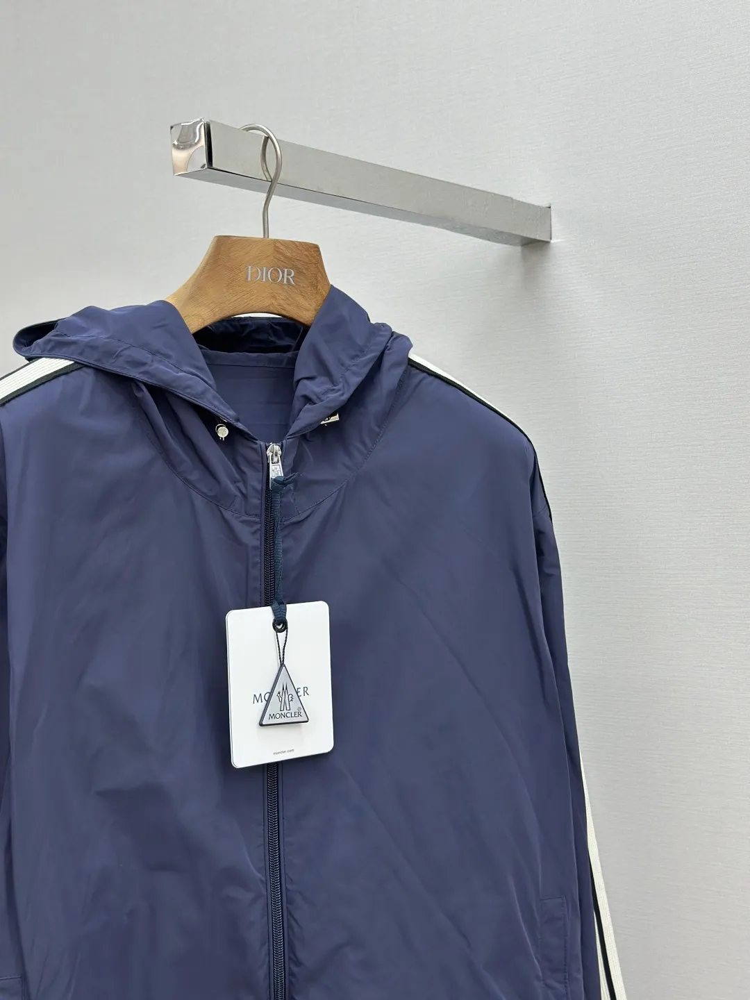 P560 MONCLER web-trimmed lightweight jacket Fabric selection: 100% polyester fiber is used to create a tough protective outer layer. It is known for its excellent tear resistance and wear resistance. It can quickly return to flatness during wearing and maintain the crisp and stylish appearance of the clothing for a long time. At the same time, it is not easy to deform after being washed for a long time.   Features: Two different colored decorative strips added to the center part of the sleeves. This design element can not only add visual highlights to clothing, making it more fashionable and unique. Craftsmanship: The webbing is precisely positioned along the cuffs to the seam of the collar and hat to ensure symmetry and overall smoothness. Before actual sewing, use very fine basting stitches for pre-fixing. This step is crucial to prevent the webbing from slipping, twisting, or wrinkling during sewing and ensuring that the final stitch is straight and perfect.  Accessories: Custom zipper puller, custom buttons with logo, custom hood drawstring elastic buckle SIZE: 1 2 3 4