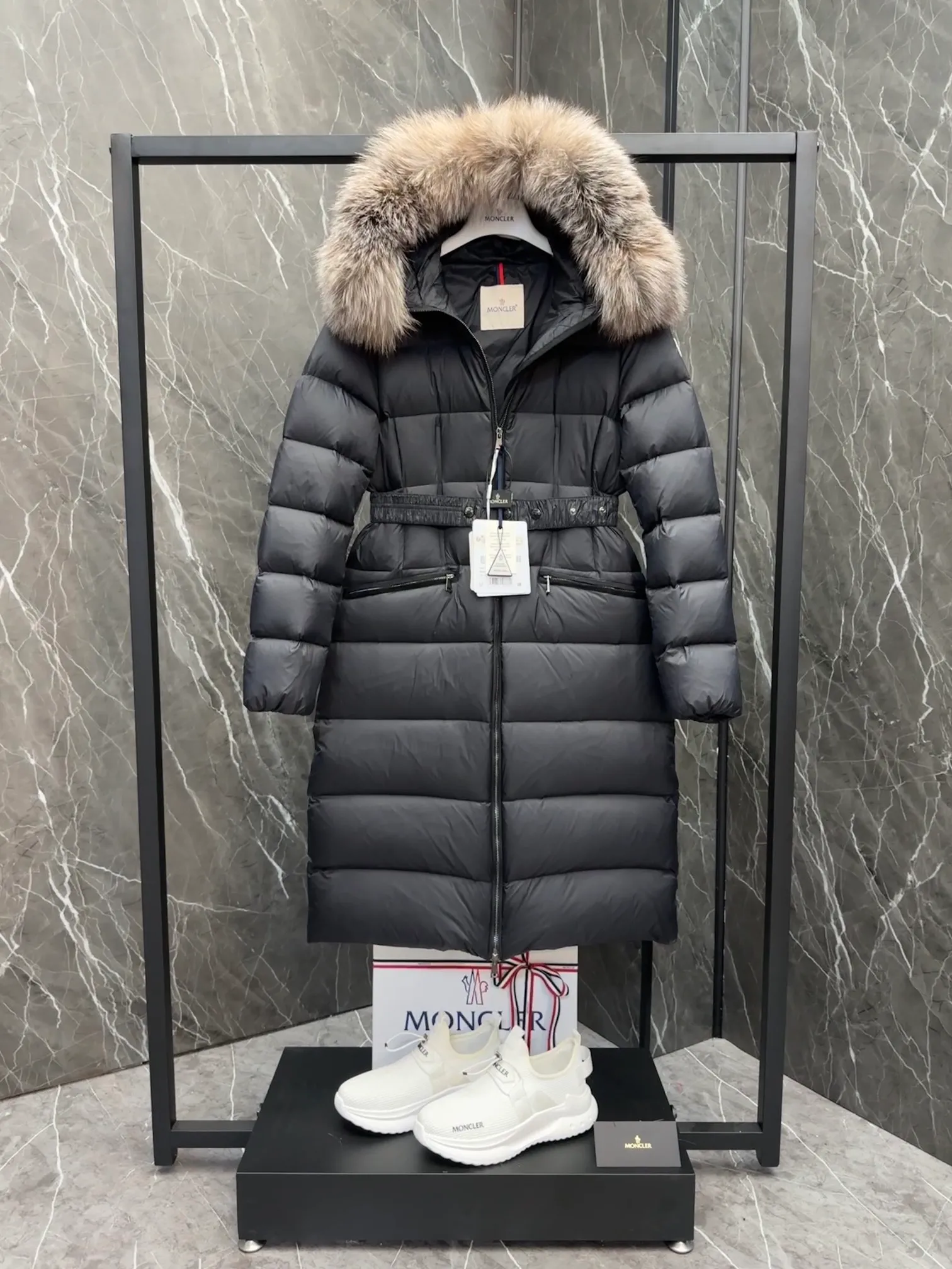 P1020 Moncler Boedic long down jacket for women. (Classic fox fur collar) adopts a whole fox fur collar imported from Finland. The Boedic long down jacket combines exquisite materials and attention to details. The timeless and elegant fashion design can provide you with a warm and caring wearing experience.  Boedic's long down jacket features a waist-cinching belt to accentuate its feminine silhouette for a stylish winter look. The cozy hood has rich fleece trim and is easily removable to suit your mood and weather conditions. Details • Made of lounge saison fabric • Longue saison lining • Filled with down • Hood with removable fox fur collar trim • Two-way zipper closure • Elastic waistband with snap button closure • Zippered pockets with grosgrain detail • Elastic cuffs Size : 1-4 .