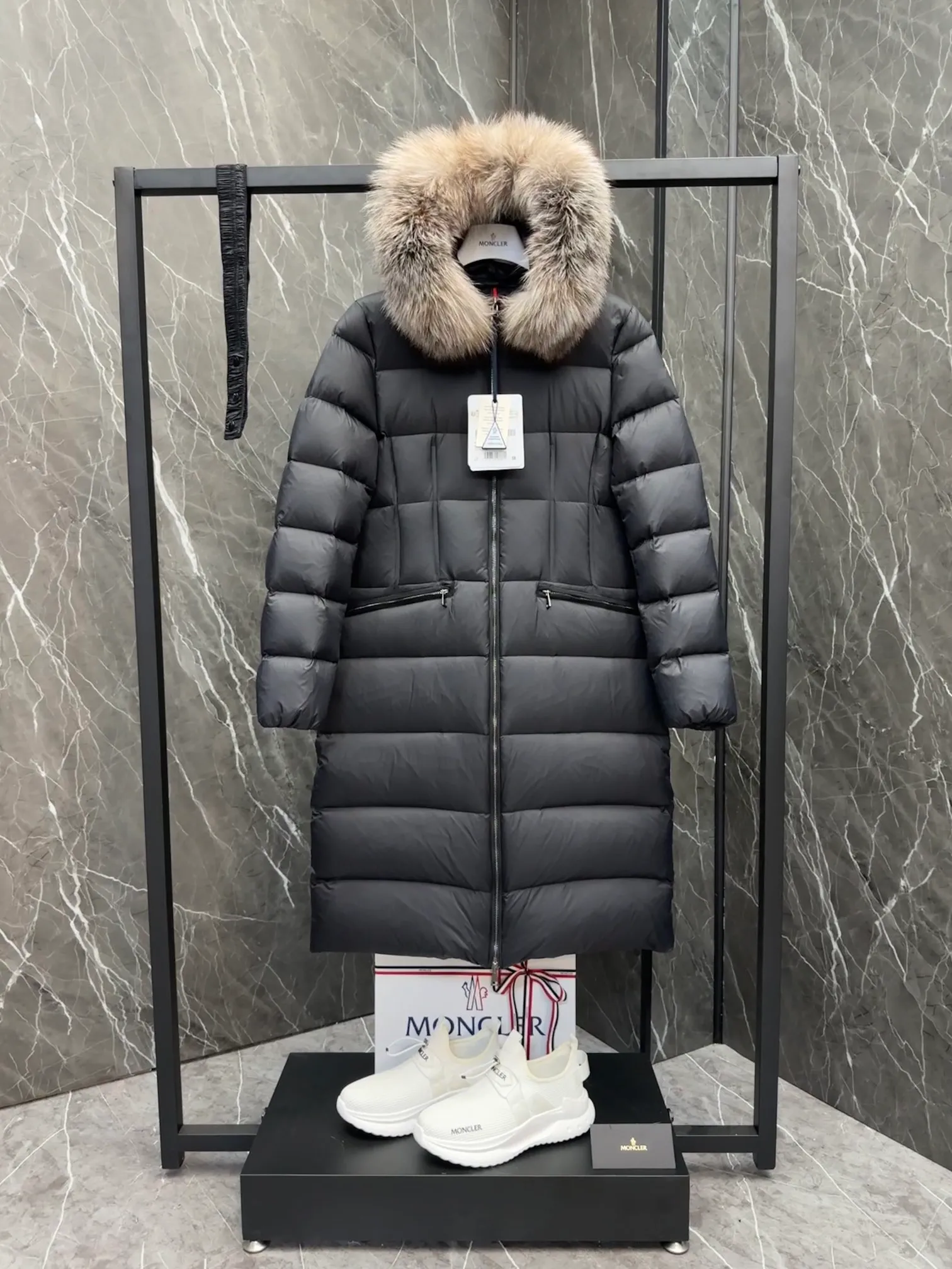 P1020 Moncler Boedic long down jacket for women. (Classic fox fur collar) adopts a whole fox fur collar imported from Finland. The Boedic long down jacket combines exquisite materials and attention to details. The timeless and elegant fashion design can provide you with a warm and caring wearing experience.  Boedic's long down jacket features a waist-cinching belt to accentuate its feminine silhouette for a stylish winter look. The cozy hood has rich fleece trim and is easily removable to suit your mood and weather conditions. Details • Made of lounge saison fabric • Longue saison lining • Filled with down • Hood with removable fox fur collar trim • Two-way zipper closure • Elastic waistband with snap button closure • Zippered pockets with grosgrain detail • Elastic cuffs Size : 1-4 .