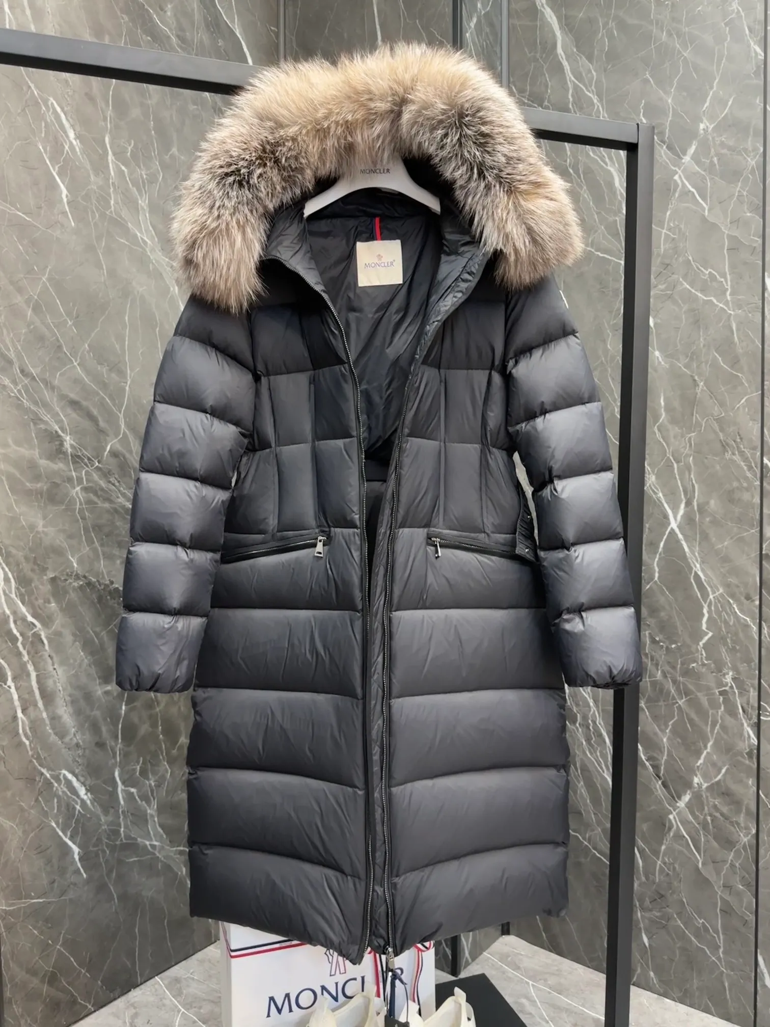 P1020 Moncler Boedic long down jacket for women. (Classic fox fur collar) adopts a whole fox fur collar imported from Finland. The Boedic long down jacket combines exquisite materials and attention to details. The timeless and elegant fashion design can provide you with a warm and caring wearing experience.  Boedic's long down jacket features a waist-cinching belt to accentuate its feminine silhouette for a stylish winter look. The cozy hood has rich fleece trim and is easily removable to suit your mood and weather conditions. Details • Made of lounge saison fabric • Longue saison lining • Filled with down • Hood with removable fox fur collar trim • Two-way zipper closure • Elastic waistband with snap button closure • Zippered pockets with grosgrain detail • Elastic cuffs Size : 1-4 .