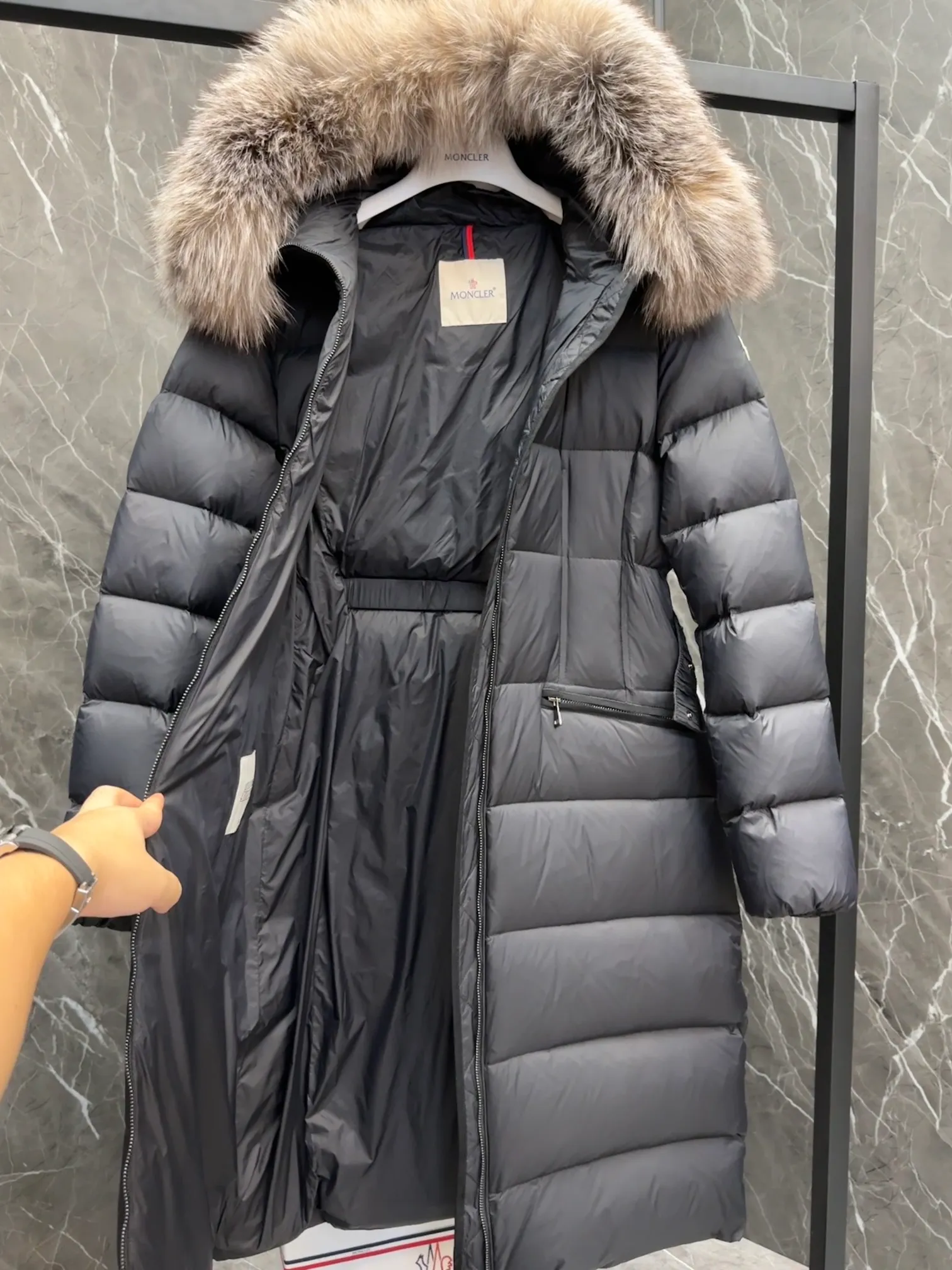 P1020 Moncler Boedic long down jacket for women. (Classic fox fur collar) adopts a whole fox fur collar imported from Finland. The Boedic long down jacket combines exquisite materials and attention to details. The timeless and elegant fashion design can provide you with a warm and caring wearing experience.  Boedic's long down jacket features a waist-cinching belt to accentuate its feminine silhouette for a stylish winter look. The cozy hood has rich fleece trim and is easily removable to suit your mood and weather conditions. Details • Made of lounge saison fabric • Longue saison lining • Filled with down • Hood with removable fox fur collar trim • Two-way zipper closure • Elastic waistband with snap button closure • Zippered pockets with grosgrain detail • Elastic cuffs Size : 1-4 .