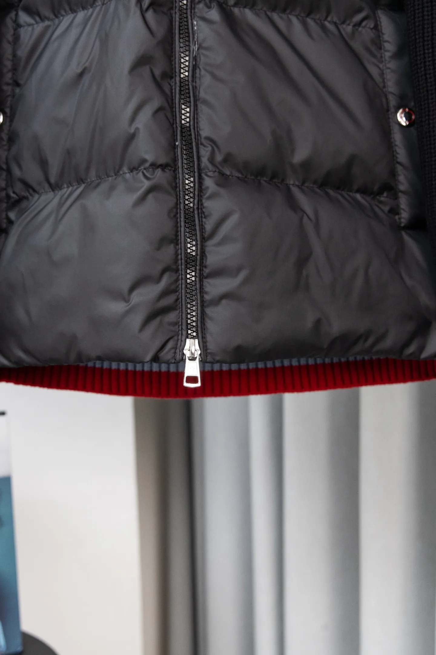 P560 Style number: M046 This is a knitted patchwork down jacket from Moncler. It combines the brand's high-end outdoor genes and fashion design. It is a luxurious item with both warmth and style in autumn and winter. Design highlights: Material splicing: Pure wool knitted sleeves are spliced ​​with a down front filled with 90 white duck down. The knitted part is soft and breathable, and the down part is fluffy and warm, achieving a dual fusion of style and function.  Detailed logo: The iconic Moncler badge pocket on the left arm is a classic embodiment of brand recognition; the stand-up collar design with a two-way zipper not only improves warmth, but also strengthens the neat styling.  Color embellishment: The contrasting red and blue stripes on the cuffs and hem inject vitality into the overall black tone, adding a retro college style charm. Craftsmanship and Quality: The down filling follows the European standard 90 down standard, with excellent fluffiness and down filling, with almost no stiff feeling. At the same time, it adopts the "line first and then separate down filling" process. The four-layer liner effectively prevents down from being drilled, and can maintain warmth even after long-term wear.  The knitted part is made of high-quality wool, which has a delicate touch and is not easily deformed. The splicing process with the down fabric is rigorous, showing a high-end texture level.  Style and Wearing This down jacket is based on the classic college style. The slim straight version can modify the body line and can be easily adapted to a variety of styles: it can be paired with jeans and casual shoes for a casual look on a daily basis. It can also be upgraded to an urban light luxury style by layering it with a turtleneck sweater inside and a suit outside. It is a key item in the winter wardrobe that is both practical and fashionable. Color: black, navy blue, sizes S-XL