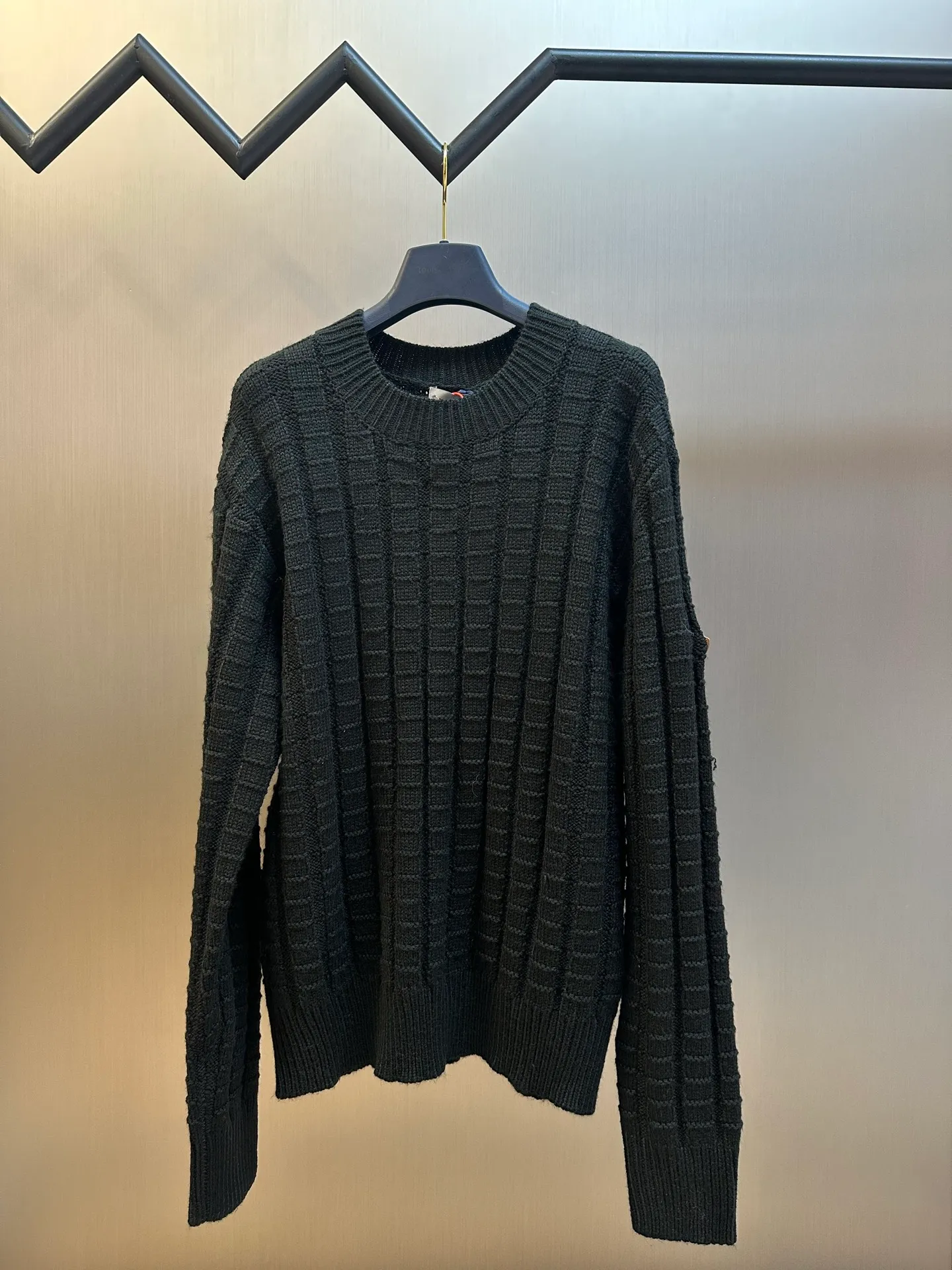 P430 Moncler embossed knitted logo sweater is made of custom-woven engraved wool texture, with three-dimensional texture as the brushstrokes. The entire embossed knitting reconstructs the dimension of knitted aesthetics. It produces a light and dark gradient texture halo as the human body moves. The iconic Moncler logo embroidered logo decorates the sleeves, making it highly recognizable.  The whole piece of embossed vertical grain knitting uses specific stitches and changes in fabric structure, and changes the arrangement of stitches and the density of the fabric, so that the vertical grains present a relief effect that is raised on the surface of the sweater, forming undulating changes in the vertical grains.  Curved thread structure, by changing the stitching method and the arrangement of yarns during the knitting process, makes the yarns present a curved distribution in the fabric.  size：s m l xl