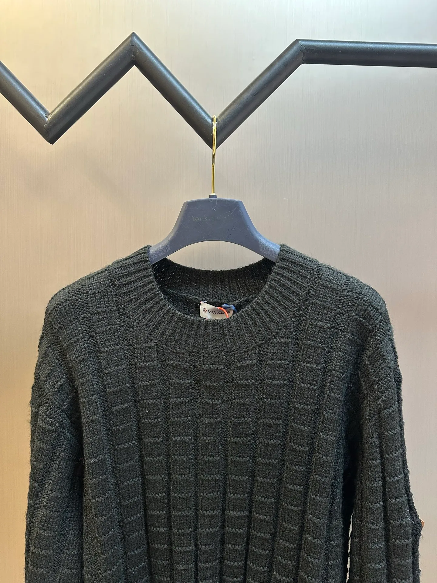 P430 Moncler embossed knitted logo sweater is made of custom-woven engraved wool texture, with three-dimensional texture as the brushstrokes. The entire embossed knitting reconstructs the dimension of knitted aesthetics. It produces a light and dark gradient texture halo as the human body moves. The iconic Moncler logo embroidered logo decorates the sleeves, making it highly recognizable.  The whole piece of embossed vertical grain knitting uses specific stitches and changes in fabric structure, and changes the arrangement of stitches and the density of the fabric, so that the vertical grains present a relief effect that is raised on the surface of the sweater, forming undulating changes in the vertical grains.  Curved thread structure, by changing the stitching method and the arrangement of yarns during the knitting process, makes the yarns present a curved distribution in the fabric.  size：s m l xl