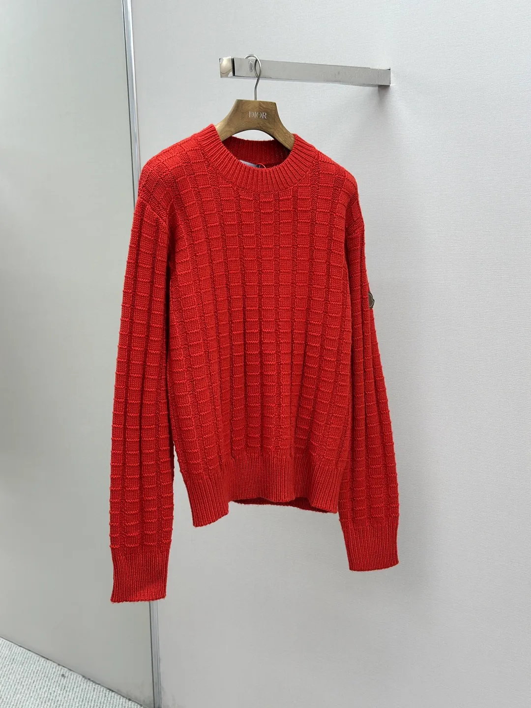 P430 Moncler logo embossed knitted crew neck sweater. The original product was purchased for 7,500. The fabric is made of custom-woven carved wool texture. It is soft and delicate, comfortable and close to the skin. It uses high-saturation red as the base color to cut through the dullness of winter. Let every inch of the fabric become an annotation of power aesthetics. Using three-dimensional texture as the brushstrokes, the entire embossed knitting reconstructs the dimension of knitted aesthetics. It produces a light and dark gradient texture halo as the human body moves. Iconic Moncler The logo embroidered logo decorates the sleeves and is highly recognizable. The power aesthetic is hidden in the contrast between hardness and softness. The ultimate expression of elegance. No need to deliberately create its own style. The whole piece is embossed vertical grain knitting. Through specific stitching and fabric tissue changes, by changing the arrangement of stitches and the density of the fabric, the vertical grains present a relief effect that is raised on the surface of the sweater. Forming undulating changes in the vertical grains and a curved thread structure. By changing the stitching and yarn arrangement during the knitting process. The yarn is distributed in a curved shape in the fabric, and the garment washing water is softened and deodorized using professional washing equipment and specific detergents to deeply clean and deodorize the clothes to improve the feel and appearance of the clothes. Size:S-M-L-XL