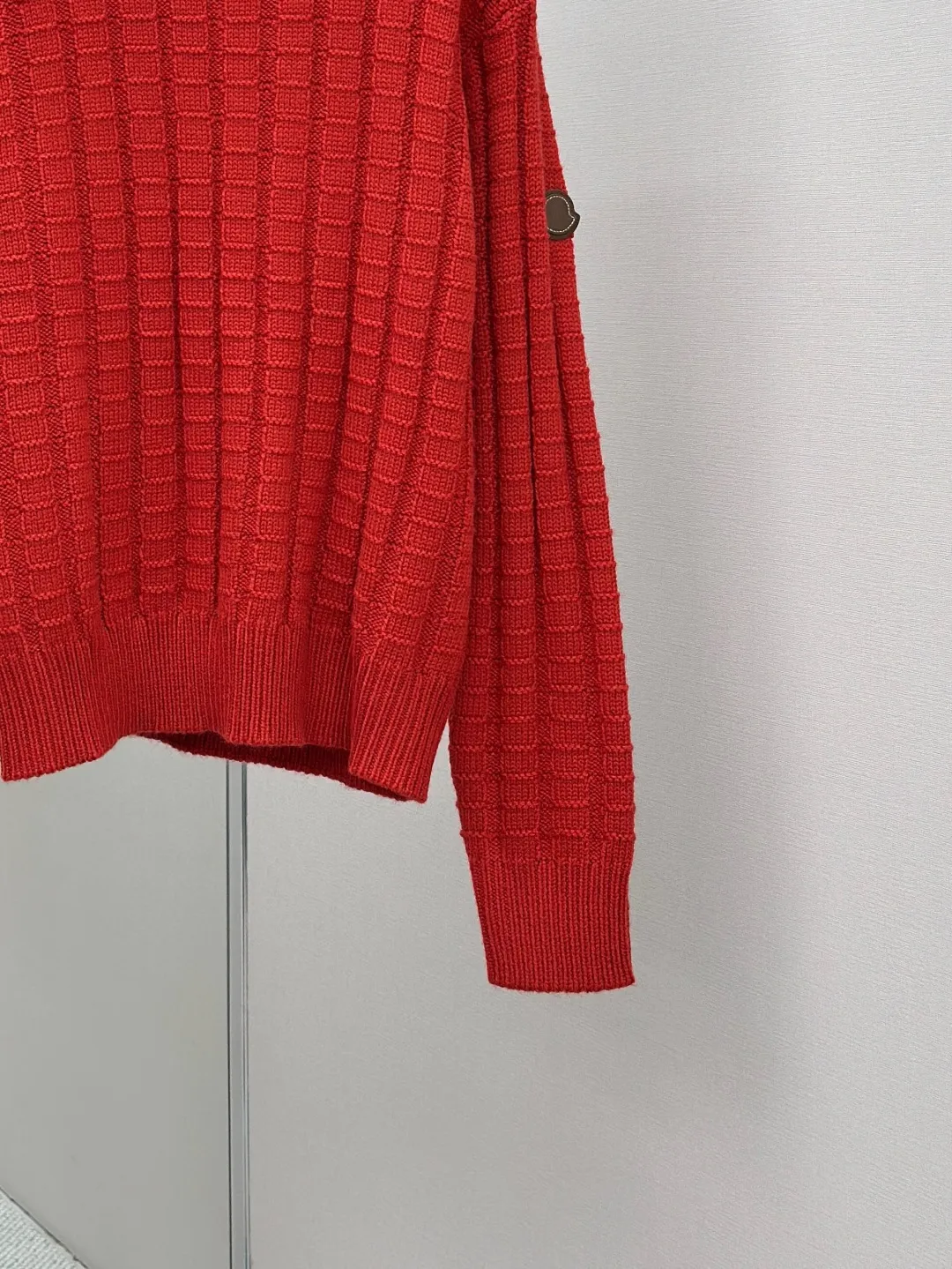 P430 Moncler logo embossed knitted crew neck sweater. The original product was purchased for 7,500. The fabric is made of custom-woven carved wool texture. It is soft and delicate, comfortable and close to the skin. It uses high-saturation red as the base color to cut through the dullness of winter. Let every inch of the fabric become an annotation of power aesthetics. Using three-dimensional texture as the brushstrokes, the entire embossed knitting reconstructs the dimension of knitted aesthetics. It produces a light and dark gradient texture halo as the human body moves. Iconic Moncler The logo embroidered logo decorates the sleeves and is highly recognizable. The power aesthetic is hidden in the contrast between hardness and softness. The ultimate expression of elegance. No need to deliberately create its own style. The whole piece is embossed vertical grain knitting. Through specific stitching and fabric tissue changes, by changing the arrangement of stitches and the density of the fabric, the vertical grains present a relief effect that is raised on the surface of the sweater. Forming undulating changes in the vertical grains and a curved thread structure. By changing the stitching and yarn arrangement during the knitting process. The yarn is distributed in a curved shape in the fabric, and the garment washing water is softened and deodorized using professional washing equipment and specific detergents to deeply clean and deodorize the clothes to improve the feel and appearance of the clothes. Size:S-M-L-XL