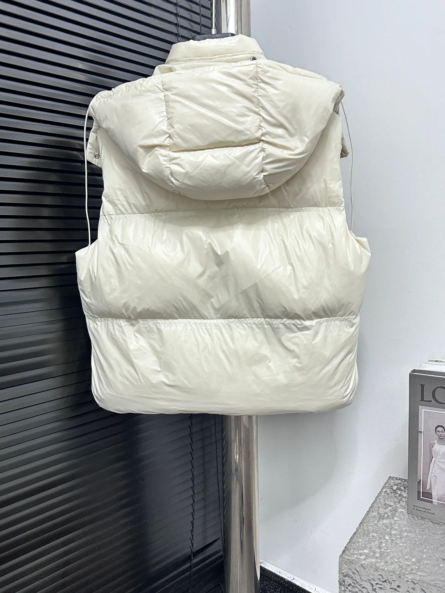 P740 [Moncler] Moncler's new autumn and winter product Pario women's hooded down vest. The Pario down vest cleverly uses shape and texture to show modern style. Made from functional super laque nylon fabric with a glossy finish. This hooded insulated piece features a double-snap closure for an asymmetrical shape. Trimmed with quilting in different sizes for a geometric feel. Size: 1-4 Color: Black Cream Mint Green