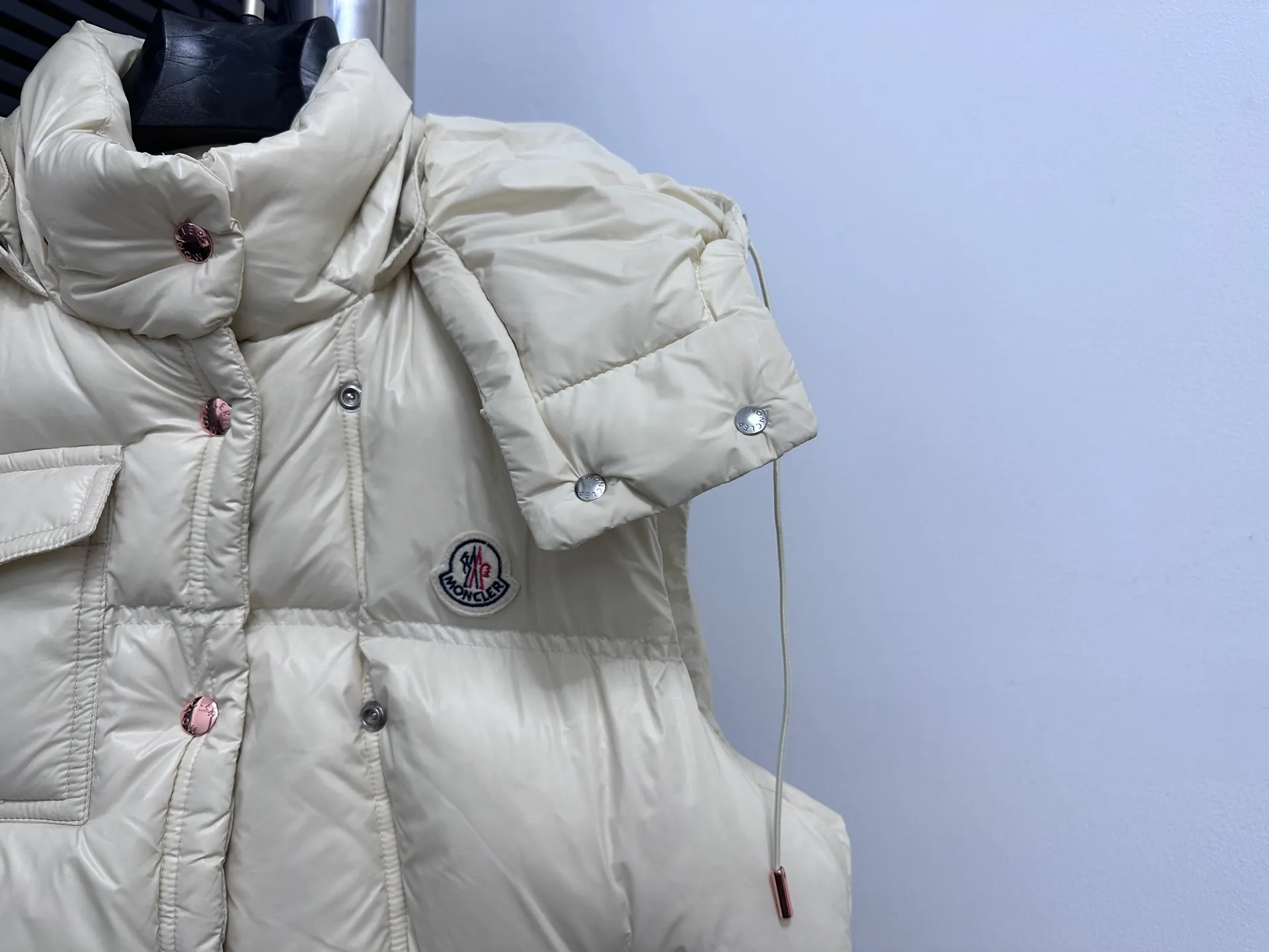 P740 [Moncler] Moncler's new autumn and winter product Pario women's hooded down vest. The Pario down vest cleverly uses shape and texture to show modern style. Made from functional super laque nylon fabric with a glossy finish. This hooded insulated piece features a double-snap closure for an asymmetrical shape. Trimmed with quilting in different sizes for a geometric feel. Size: 1-4 Color: Black Cream Mint Green