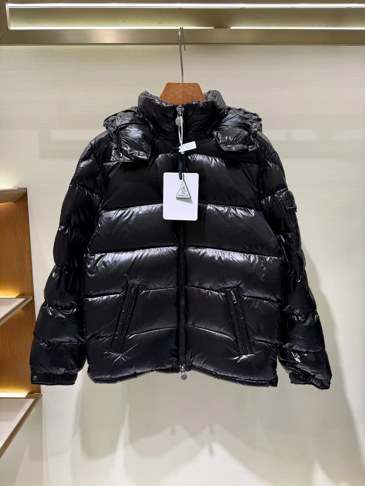 P1180 Moncler Maya Men's Men's Short Down Jacket The Moncler Maya men's down jacket is made of shiny patented nylon with signature rectangular quilting, which is a model of Moncler style. A classic cropped design that transcends seasons and styles, it features a statement silhouette, removable hood and adjustable hem. The sleeves are embellished with classic patch pockets, showcasing the brand's signature style.  Fabric: 100% nylon, 90% white goose down Craftsmanship: Made of lacquered nylon, lacquered nylon lining filled with down, rectangular quilting, detachable hood with snaps that can be adjusted by drawstring, two-way zip fly, external and internal zippered pockets, adjustable elastic cuffs with snaps, hood with drawstring, sleeves with flap patch pockets, sleeves decorated with Moncler felt trademark.  Size: 123456 0548000