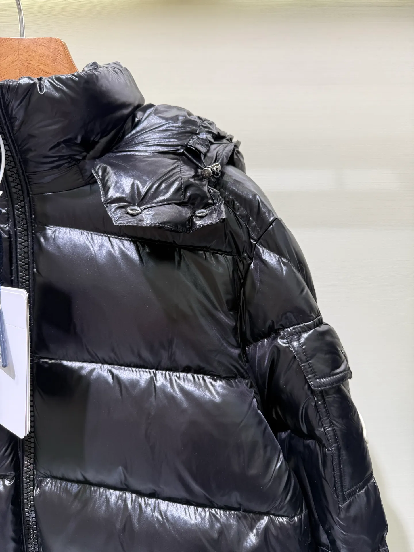 P1180 Moncler Maya Men's Men's Short Down Jacket The Moncler Maya men's down jacket is made of shiny patented nylon with signature rectangular quilting, which is a model of Moncler style. A classic cropped design that transcends seasons and styles, it features a statement silhouette, removable hood and adjustable hem. The sleeves are embellished with classic patch pockets, showcasing the brand's signature style.  Fabric: 100% nylon, 90% white goose down Craftsmanship: Made of lacquered nylon, lacquered nylon lining filled with down, rectangular quilting, detachable hood with snaps that can be adjusted by drawstring, two-way zip fly, external and internal zippered pockets, adjustable elastic cuffs with snaps, hood with drawstring, sleeves with flap patch pockets, sleeves decorated with Moncler felt trademark.  Size: 123456 0548000