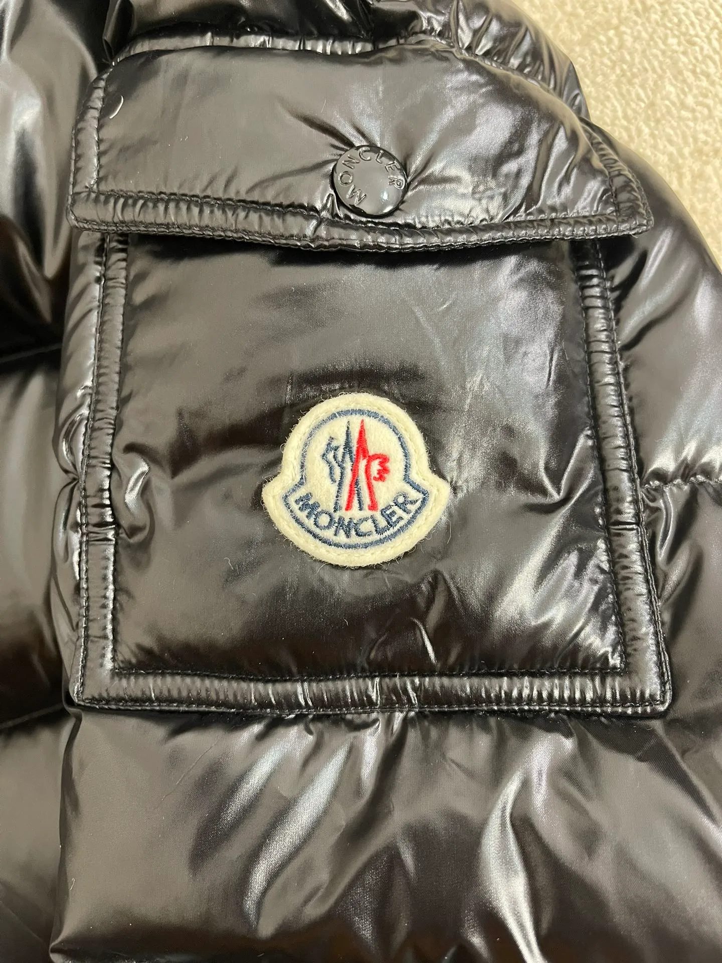 P1180 Moncler Maya Men's Men's Short Down Jacket The Moncler Maya men's down jacket is made of shiny patented nylon with signature rectangular quilting, which is a model of Moncler style. A classic cropped design that transcends seasons and styles, it features a statement silhouette, removable hood and adjustable hem. The sleeves are embellished with classic patch pockets, showcasing the brand's signature style.  Fabric: 100% nylon, 90% white goose down Craftsmanship: Made of lacquered nylon, lacquered nylon lining filled with down, rectangular quilting, detachable hood with snaps that can be adjusted by drawstring, two-way zip fly, external and internal zippered pockets, adjustable elastic cuffs with snaps, hood with drawstring, sleeves with flap patch pockets, sleeves decorated with Moncler felt trademark.  Size: 123456 0548000
