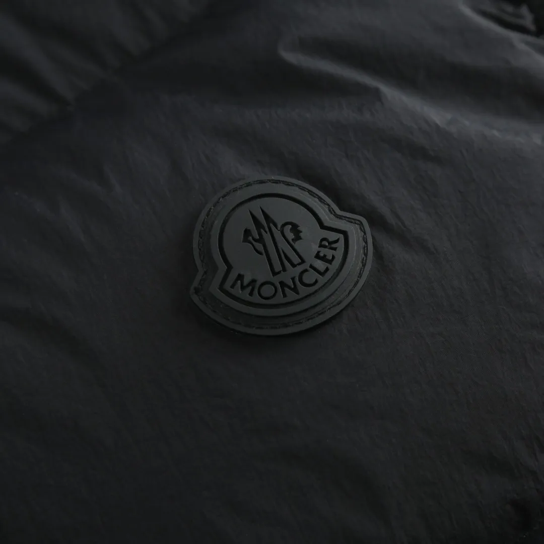 P680 MONCLER Badge Hooded Down Vest Fabric selection: Made of nylon fabric made of 100% nylon, which is woven into a tight and tough fabric through advanced textile technology, which increases the strength of the skeleton to effectively block the invasion of cold wind and lock the warm air generated by the down layer. After tight weaving and special treatment, it is waterproof and windproof. The surface forms a certain lotus leaf effect, and is wrinkle-resistant and not easily deformed, making it easy for daily care.  Technology: The quilting stitches are sewn in a diagonal direction at an angle of approximately 70 degrees. The diagonal lines are arranged in parallel. The fabric and filling are planned into different functional areas, and the quilting stitches in each partition are relatively independent. This allows the finished product to produce a larger deformation space along the diagonal direction when stretched and pressed, making it less likely to tighten and break, and has rich visual effects, modern and advanced features.  Details: After the hood is removed, the stand-up collar displays an embossed logo of the same color, adding a unique visual experience and tactile details.  High-quality filling: It is filled with 90% selected white duck down, weighing 170g, ensuring fluffy rebound, lightness and warmth.  Accessories: One-to-one customized zipper pendant, one-to-one customized badge, one-to-one customized three-label SIZE: 1 2 3 4