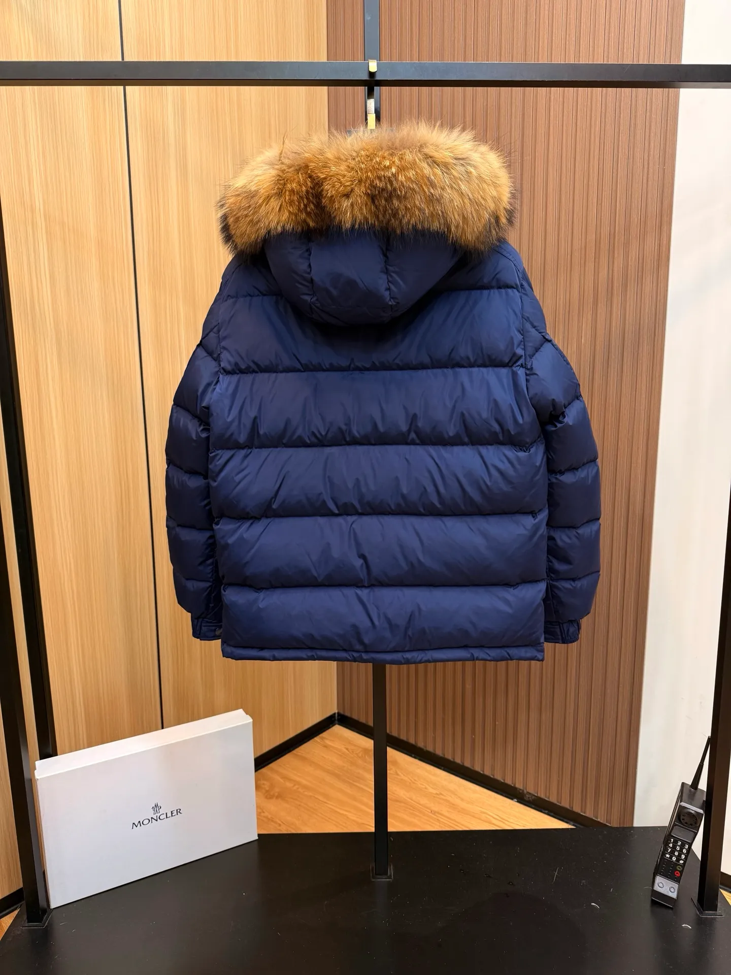 P1040 Moncler Mayaf short men's down jacket. The hood is removable. The fur collar is removable. Based on Maya, a removable fur collar is added. The Mayaf men's hooded down jacket is made of functional nylon fabric, and the hood is equipped with removable synthetic material trim.  The Mayaf short down jacket is a reinterpretation of the classic Moncler Maya style in an instantly recognizable silhouette, with a removable hood and adjustable hem. Made from functional fabric with removable synthetic trim on the hood. The sleeves are embellished with classic patch pockets, reflecting the brand's signature style. Details •Made from functional fabric •Technical fabric lining •Down-filled •Push-stud collar •Detachable hood with removable synthetic trim •Zip closure •Zip pockets •Patch pockets with press-stud •Adjustable elastic cuffs •Adjustable drawstring hem