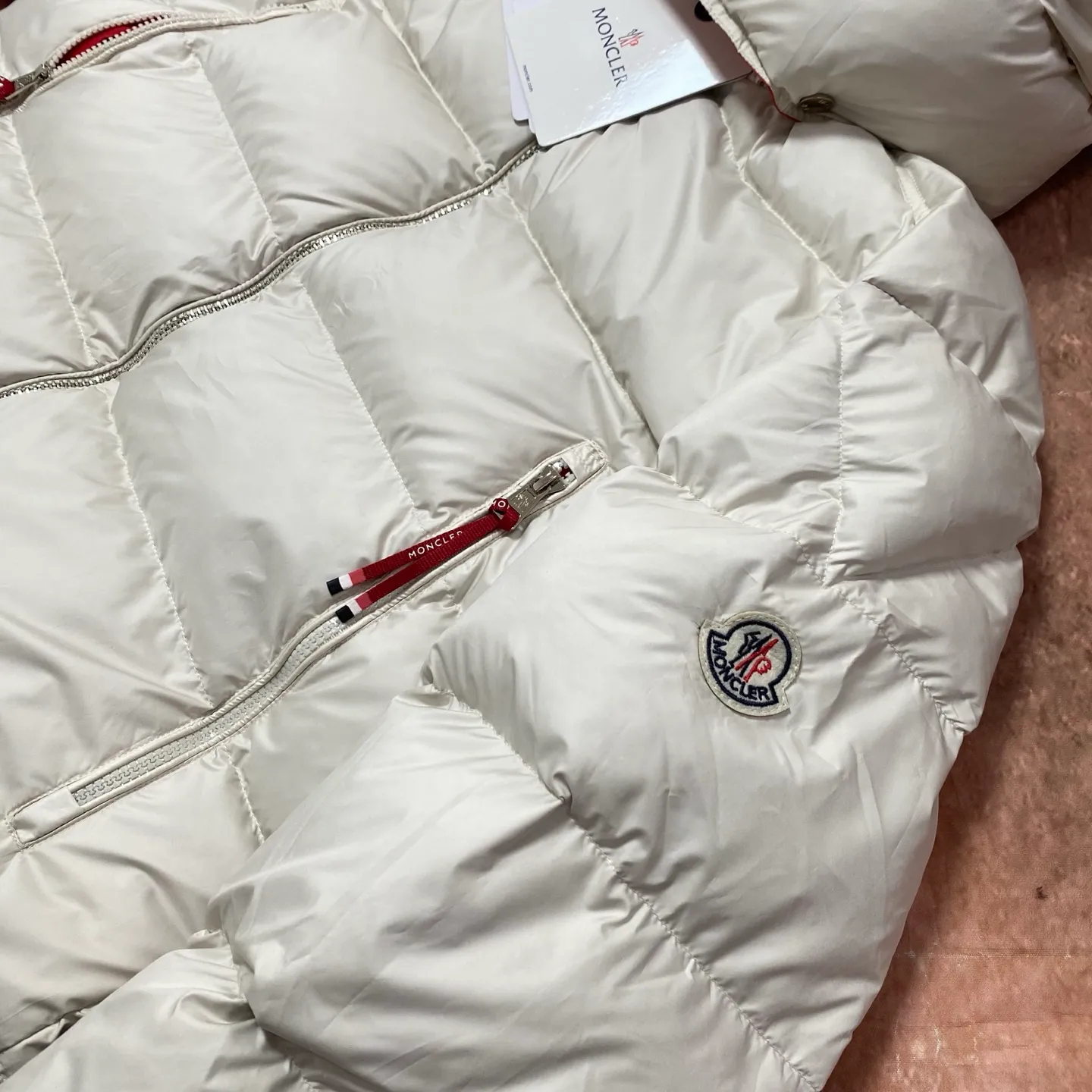 P760 Moncler Mouth Mouth National Standard 90 white duck down filling Poirier down draws inspiration from skiing in the 1960s and is stylish. Made of tight nylon fabric with excellent breathability and functionality, the hooded design is an example of Moncler's research into fabrics. The berry-colored details on the brim and zipper give the whole thing a refreshing touch, and are the same style for men and women. Color: Off-white Size: MLXL