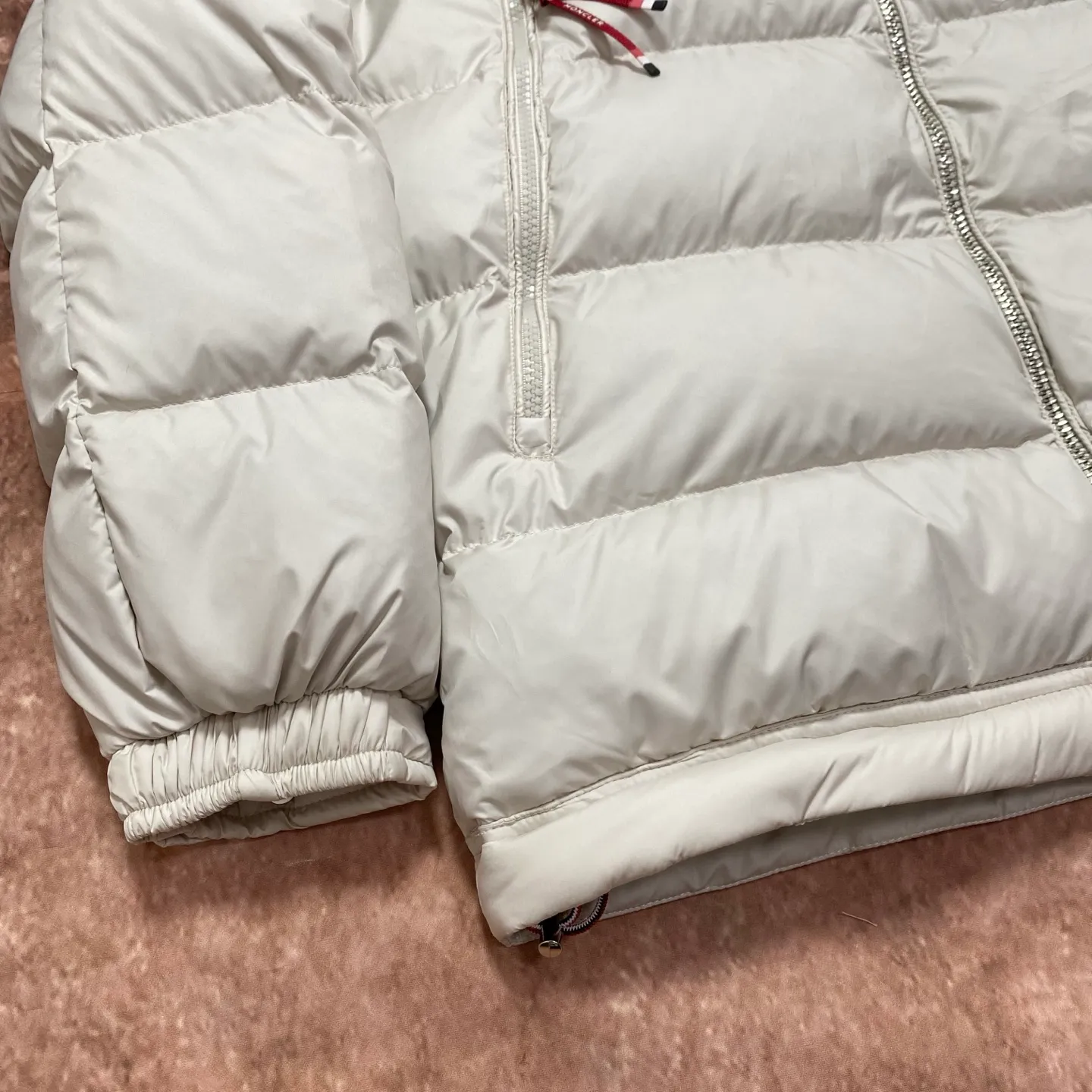 P760 Moncler Mouth Mouth National Standard 90 white duck down filling Poirier down draws inspiration from skiing in the 1960s and is stylish. Made of tight nylon fabric with excellent breathability and functionality, the hooded design is an example of Moncler's research into fabrics. The berry-colored details on the brim and zipper give the whole thing a refreshing touch, and are the same style for men and women. Color: Off-white Size: MLXL