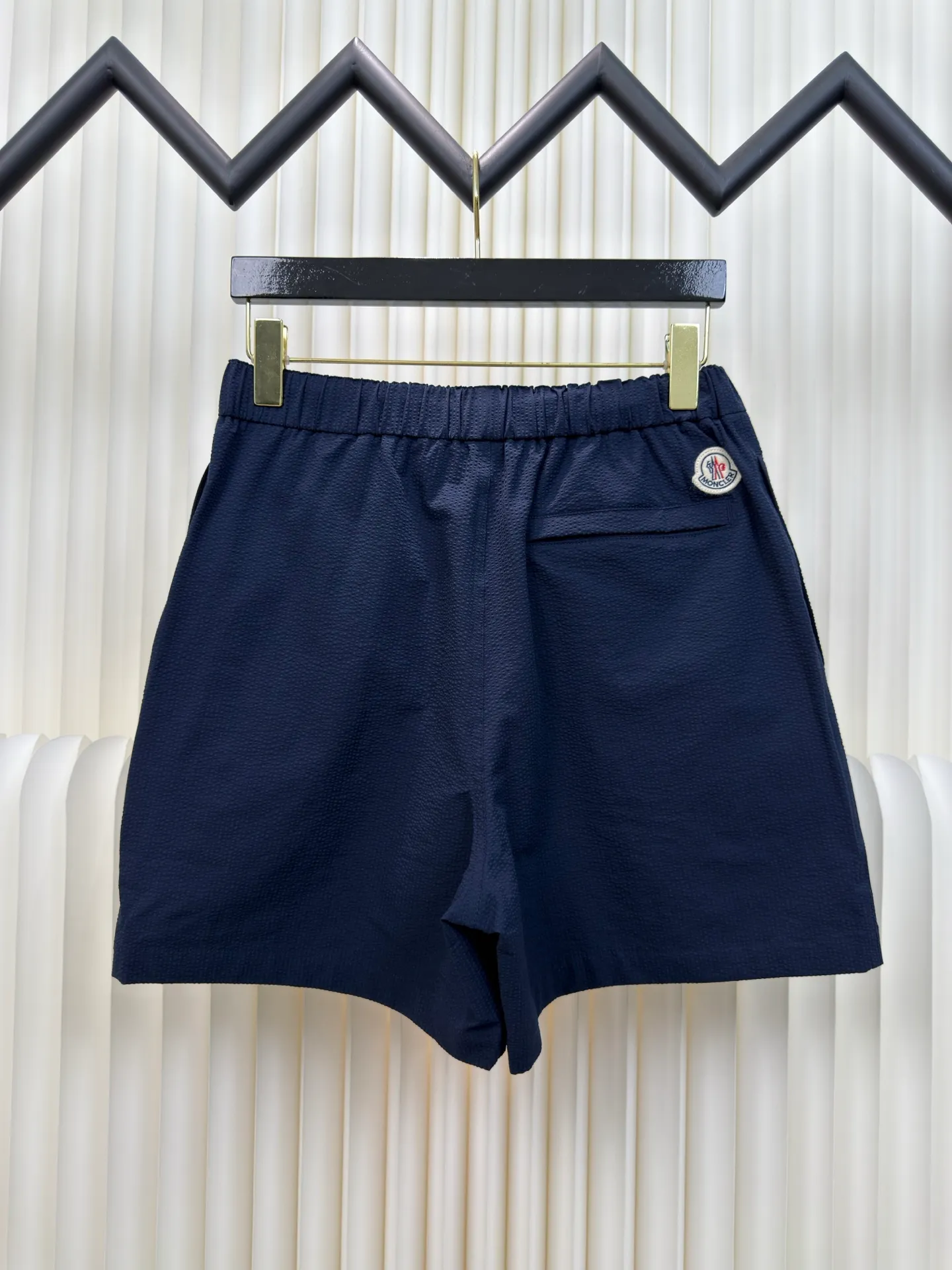 P310 MONCLER Puff Wrinkle Label Shorts with Mouth, Authentic Open Version - Physical Counter - Top Luxury Quality 🆚Second Price of All Versions on the Market Made of cotton blended woven fabric with 76% high cotton content + 24% polyester fiber. The high cotton content ensures that the fabric is soft, skin-friendly, and has good breathability. The addition of a small amount of polyester fiber balances the wrinkle resistance and elasticity of the overall fabric and greatly reduces its shrinkage. After preshrinking, dimensional changes during washing are negligible. The fusion of the two makes the fabric combine anti-wrinkle, quick-drying, easy care and other characteristics without losing the advantages of good wearing experience and strong breathability.  Bubble wrinkle technology: ground warp + bubble warp independent let-off. The bubble warp yarn feeding speed is about 20% higher than the ground warp yarn feeding speed. During weaving, the bubble warp is relaxed and accumulated, forming a naturally arched bubble unit. Through the alternating arrangement of yarns + floating length tissue changes, a clear grid frame is built between the bubble units, and finally the bubble three-dimensional effect and grid outline are locked through high-temperature heat setting. Size 1 2 3 4