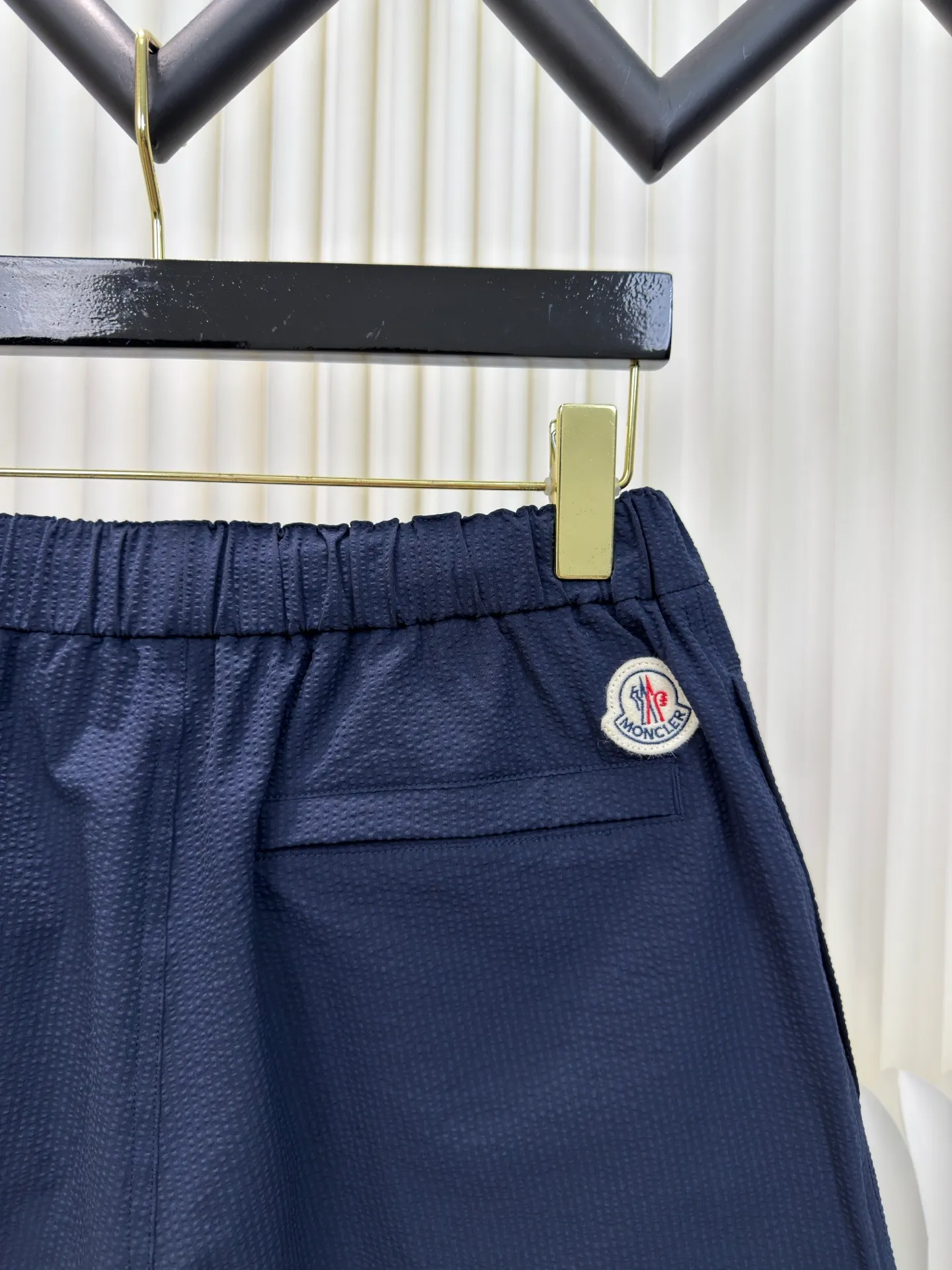 P310 MONCLER Puff Wrinkle Label Shorts with Mouth, Authentic Open Version - Physical Counter - Top Luxury Quality 🆚Second Price of All Versions on the Market Made of cotton blended woven fabric with 76% high cotton content + 24% polyester fiber. The high cotton content ensures that the fabric is soft, skin-friendly, and has good breathability. The addition of a small amount of polyester fiber balances the wrinkle resistance and elasticity of the overall fabric and greatly reduces its shrinkage. After preshrinking, dimensional changes during washing are negligible. The fusion of the two makes the fabric combine anti-wrinkle, quick-drying, easy care and other characteristics without losing the advantages of good wearing experience and strong breathability.  Bubble wrinkle technology: ground warp + bubble warp independent let-off. The bubble warp yarn feeding speed is about 20% higher than the ground warp yarn feeding speed. During weaving, the bubble warp is relaxed and accumulated, forming a naturally arched bubble unit. Through the alternating arrangement of yarns + floating length tissue changes, a clear grid frame is built between the bubble units, and finally the bubble three-dimensional effect and grid outline are locked through high-temperature heat setting. Size 1 2 3 4