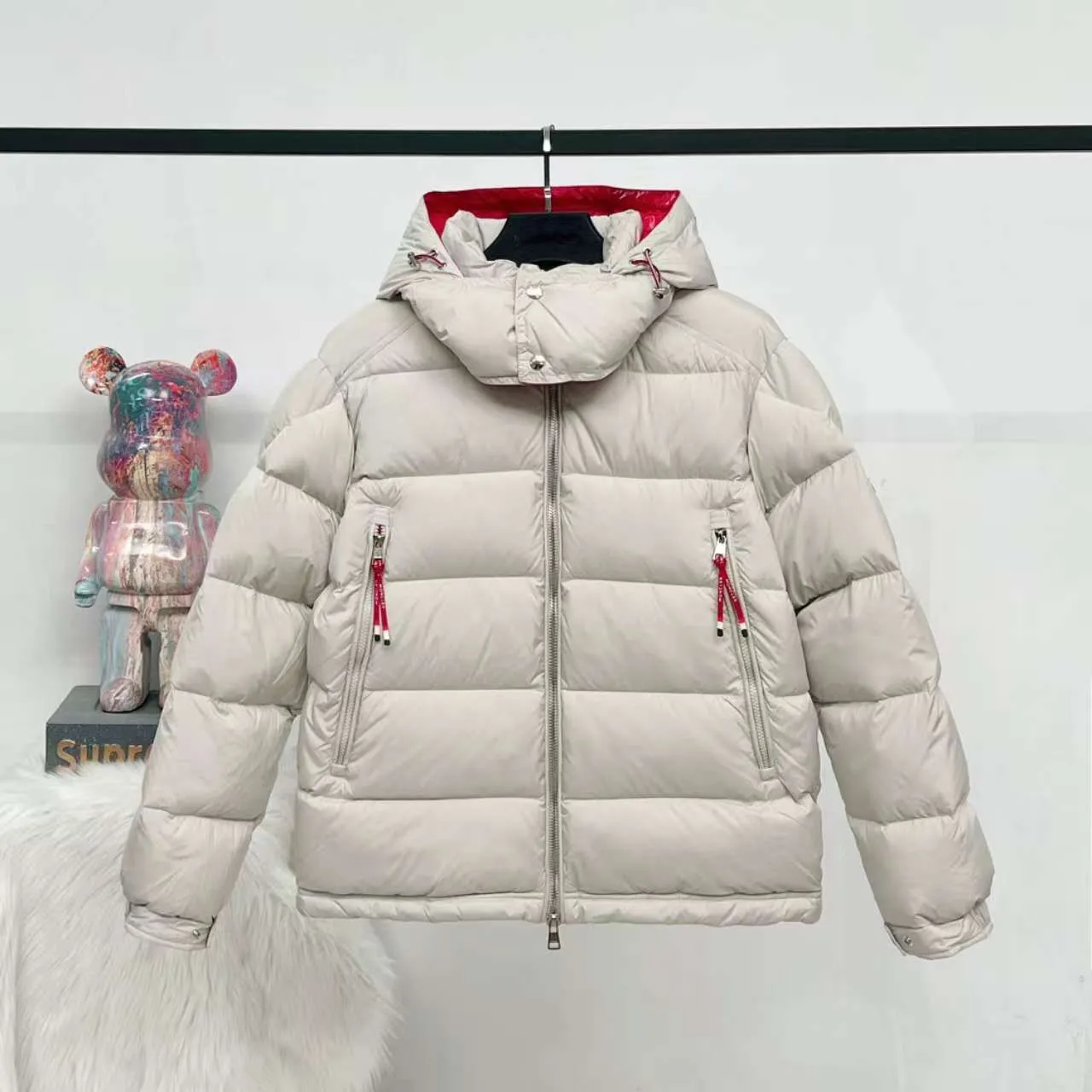 P840 top version] Large goods hanging photo Moncler masked down jacket in off-white (hat with red splicing design) and black styles, both have a detachable hood design. The red elements in details such as zippers and pockets add a sense of design to the overall shape. It is in line with the brand's style characteristics of focusing on both functionality and fashion. It is suitable for wearing in cold weather and has both warmth and trendy attributes. It has achieved a series of misunderstandings such as the original NFC inductive anti-counterfeiting chip, the national standard 95% pure white duck down, the exclusive use of top-grade down on the market, and never fake goose down. Perfect filling using direct velvet filling technology, the fluffy texture is very good. The lightness, warmth and cold protection ability are improved to the maximum. The original processing factory produces electroplated hardware, all customized by the original factory, and not all types of replicas on the market. Style number: 5607# Color: black. Off-white Code number: 1.2.3.4.5