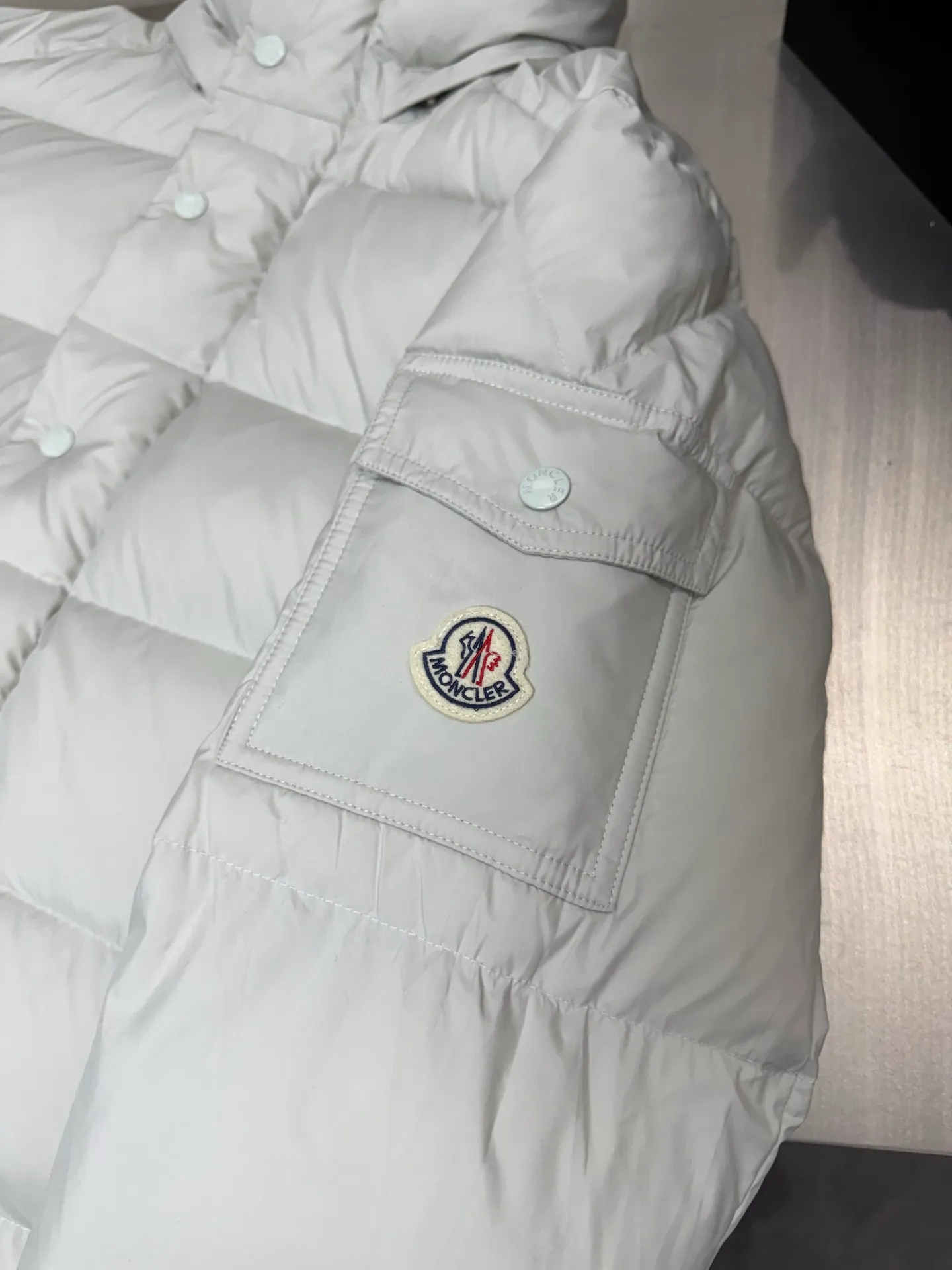 P820 ​​Moncler Mouth Matte Maya Short Down Jacket This short parka down jacket is made of longueSaion fabric. The garment is full of functional details to ensure warmth and care. Features removable hood, zip pockets, adjustable cuffs, and snap-zip flap fly. Logo embellished sleeves. It adds a unique touch to the overall shape while significantly improving the protective performance. Color: black, white, off-white, pearl white, pink. Size: 12345