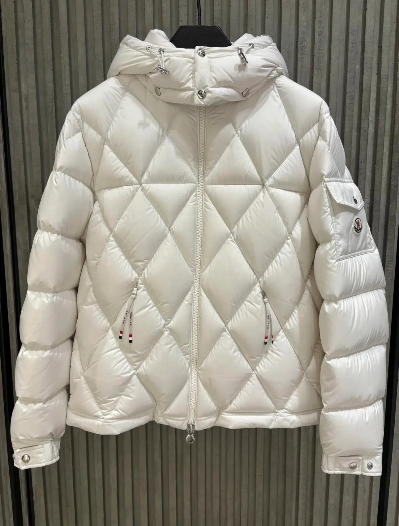 P840 Chiped Premium Down Moncler Averole Short Men's Diamond Check Down Jacket Jacket. Premium goose down filling. Original matching hardware. The Averole Men's Short Down Jacket features an eye-catching stitching pattern that combines diamond quilted yoke and long square quilted body. The Averole Men's Short Down Jacket features an eye-catching stitching pattern, diamond-quilted yoke and long checkered quilting throughout. Made from stretch nylon and features a removable hood, pockets and two-way zip fly. Details •Made from stretch nylon fabric •Stretch nylon lining •Down filling •Detachable and adjustable hood with press studs and drawstring •Diamond quilted yoke •Zip closure •Zip pockets •Adjustable cuffs with press studs •Fleece felt logo Size: 1-5 Black White