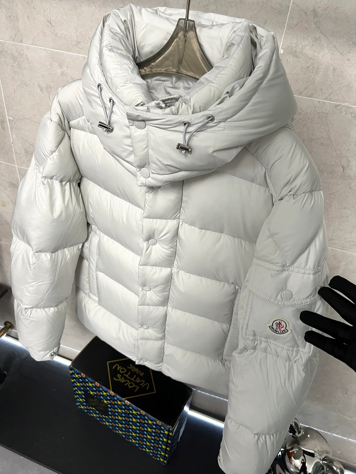 P800 Moncler matte Maya short down jacket. This short parka down jacket is made of longueSaion fabric. The garment is full of functional details to ensure warmth and care. Features removable hood, zip pockets, adjustable cuffs, and snap-zip flap fly. Logo embellished sleeves. It adds a unique touch to the overall shape and significantly improves the protective performance. Color: Black White Pink Pearl White Size: 12345