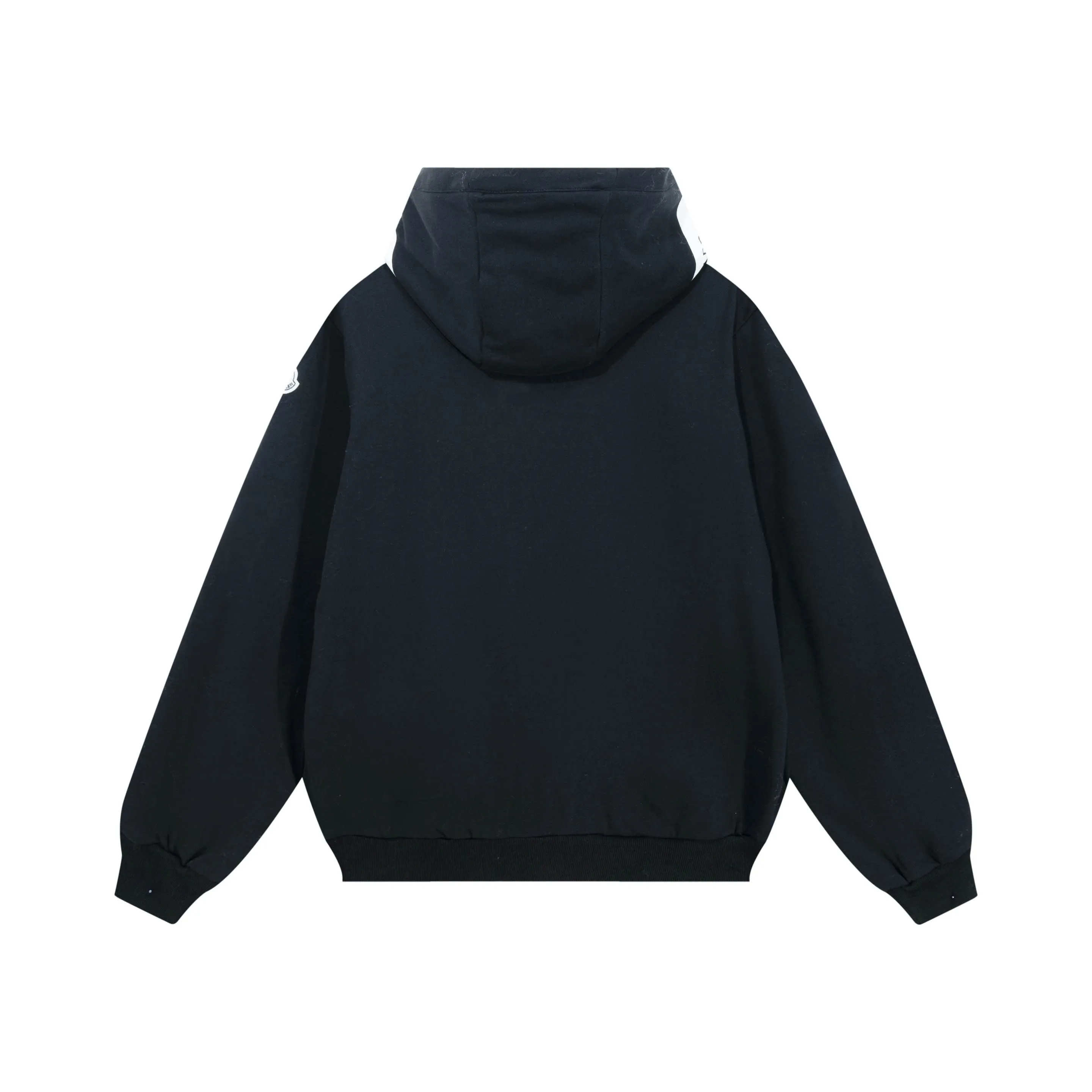 P340 Moncler slogan printed zipper hooded jacket is made of lightweight turned velvet cotton fabric. High-density cotton fiber is used to achieve internal and external differentiation in a single layer of fabric. The outer plain weave is tight and wear-resistant, and the inner layer is sanded to form a short dense suede surface. The dense plain weave structure resists wind and splashes, the brushed suede surface is skin-friendly, and the short pile has been treated to eliminate static electricity to avoid sticking to the skin. A very small amount of grooved polyester moisture-conducting yarn is embedded in the cotton fiber, which quickly guides sweat from the inner suede surface to the outer layer for evaporation through the capillary effect, solving the problem of the suede being easily stuffy. By actively interfering with the shrinkage potential of cotton fibers, the fabric is able to transition from changeable to stable, improving dimensional stability while being less prone to deformation and wrinkles. High saturation is achieved on the center of the cap through glue printing. Size: xs-l