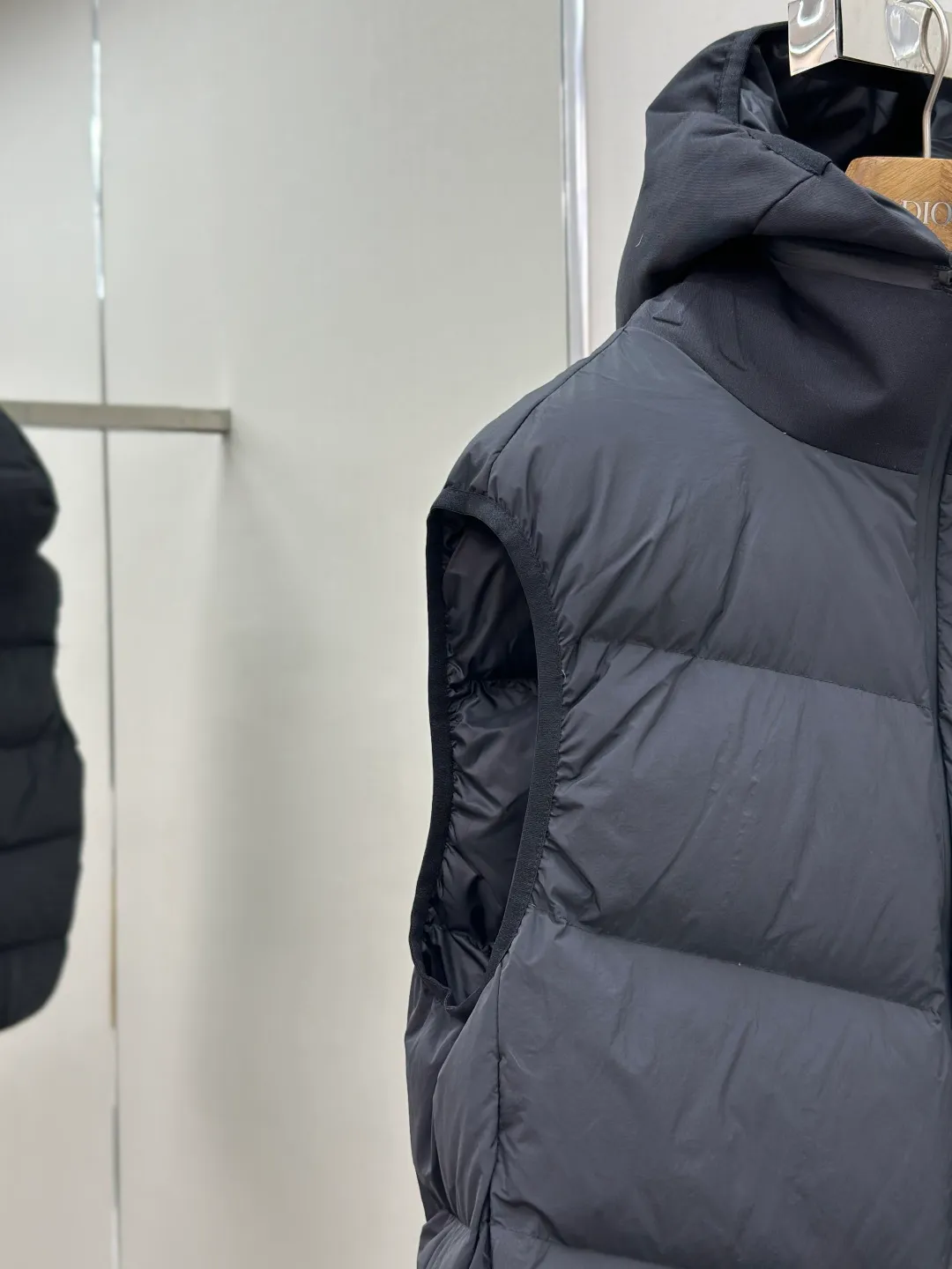 P660 MONCLER Badge Hooded Down Vest Fabric selection: Made of nylon fabric made of 100% nylon, which is woven into a tight and tough fabric through advanced textile technology. It improves the strength of the skeleton to effectively block the invasion of cold wind and lock the warm air generated by the down layer. After tight weaving and special treatment, it has waterproof and windproof functions. The surface forms a certain lotus leaf effect, and is wrinkle-resistant and not easily deformed, making it easy for daily care.  Technology: The quilting stitches are sewn in a diagonal direction at an angle of approximately 70 degrees. The diagonal lines are arranged in parallel. The fabric and filling are planned into different functional areas, and the quilting stitches in each partition are relatively independent. This allows the finished product to produce a larger deformation space along the diagonal direction when stretched and pressed, making it less likely to tighten and break, and has rich visual effects, modern and advanced features.  Details: After the hood is removed, the stand-up collar displays an embossed logo of the same color, adding a unique visual experience and tactile details.  High-quality filling: It is filled with 90% selected white duck down, weighing 170g, ensuring fluffy rebound, lightness and warmth.  Accessories: One-to-one customized zipper pendant, one-to-one customized badge, one-to-one customized three-label SIZE: 1 2 3 4