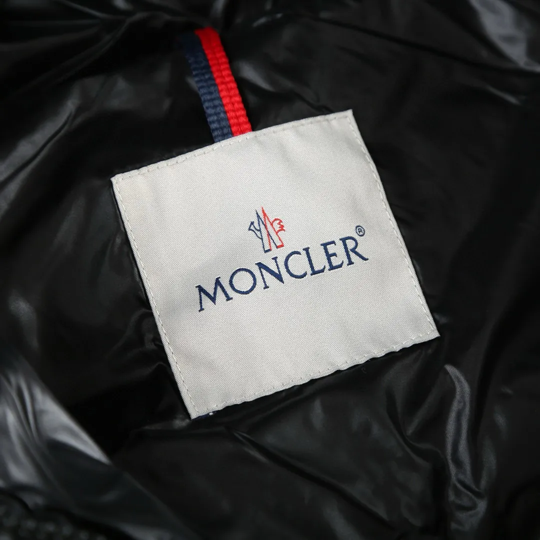 P910 [Exclusive supply] Moncler hooded brim quilted embroidered down jacket (black). The high-quality filling is made of 90 selected white duck down, with a weight of 210g, ensuring fast fluffy rebound, lightness and warmth. The fabric is made of longue saison fabric made of high-count polyamide fiber, which is famous for its excellent tensile strength and lightness. Its good flexibility makes the fabric less prone to wrinkles and keeps it crisp and stylish for a long time. The tight weave effectively blocks the invasion of cold wind and locks in the warm air generated by the down layer. The high-density nylon surface forms a certain lotus leaf effect, making it difficult for small water droplets to penetrate, keeping the interior dry and effectively extending the service life of the down. The lining is made of ultra-fine denier woven high-density lining, with a thickness of 0.08mm to avoid increasing the overall weight and making it smooth to wear. The high-density woven structure forms a wind resistance layer to protect the thermal efficiency of the thermal layer from loss. It can also withstand the expansion pressure of down and prevent deformation and damage after long-term use. The quilted letter logo on the brim uses contour quilting technology. The stitches are routed along the edge of the set outline, and the filler is compressed inside the letter graphic, so that the logo is three-dimensional and the pattern is clear. Size:1-2-3-3
