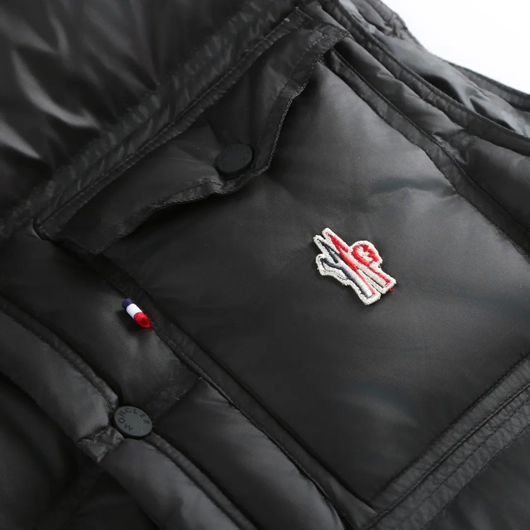 P680 MONCLER down vest with reflective markings Fabric selection: Made of ultra-fine nylon yarn woven in a high-density manner. The number of yarns per unit area is large, and the gaps between the yarns are very small, which can effectively block the penetration of cold wind. The fine weave keeps it lightweight and soft to the touch, physically restricting the lightweight down fibers from slipping through the gaps. Nylon fiber itself has good wear resistance and is not easy to snag, which significantly extends its service life and can easily cope with the needs of multiple scenarios.  Lining selection: The lining is made of 100% polyester fiber high-density weaving. The thickness of 0.08mm avoids increasing the overall weight and makes it smooth to wear. The high-density weaving structure forms a wind resistance layer to protect the thermal efficiency of the thermal insulation layer from loss. At the same time, it can withstand the expansion pressure of down and prevent deformation and damage after long-term use.  High-quality filling: 90 white duck down is selected, with a weight of 130g, ensuring excellent thermal insulation performance. After strict screening and processing, the velvet is not easy to get drilled, ensuring durability.  Process: Through the reflective cloth punching process, the logo is regularly arranged on the triangular reflective mark with dozens of small holes, which not only improves the functionality, but also strengthens the recognition and aesthetics.   Accessories: One-to-one customized snap buttons, one-to-one customized zipper pullers, one-to-one customized badges, one-to-one customized elastic buckles, etc. SIZE: 1 2 3 4