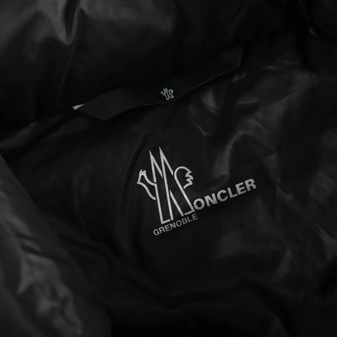 P680 MONCLER down vest with reflective markings Fabric selection: Made of ultra-fine nylon yarn woven in a high-density manner. The number of yarns per unit area is large, and the gaps between the yarns are very small, which can effectively block the penetration of cold wind. The fine weave keeps it lightweight and soft to the touch, physically restricting the lightweight down fibers from slipping through the gaps. Nylon fiber itself has good wear resistance and is not easy to snag, which significantly extends its service life and can easily cope with the needs of multiple scenarios.  Lining selection: The lining is made of 100% polyester fiber high-density weaving. The thickness of 0.08mm avoids increasing the overall weight and makes it smooth to wear. The high-density weaving structure forms a wind resistance layer to protect the thermal efficiency of the thermal insulation layer from loss. At the same time, it can withstand the expansion pressure of down and prevent deformation and damage after long-term use.  High-quality filling: 90 white duck down is selected, with a weight of 130g, ensuring excellent thermal insulation performance. After strict screening and processing, the velvet is not easy to get drilled, ensuring durability.  Process: Through the reflective cloth punching process, the logo is regularly arranged on the triangular reflective mark with dozens of small holes, which not only improves the functionality, but also strengthens the recognition and aesthetics.   Accessories: One-to-one customized snap buttons, one-to-one customized zipper pullers, one-to-one customized badges, one-to-one customized elastic buckles, etc. SIZE: 1 2 3 4