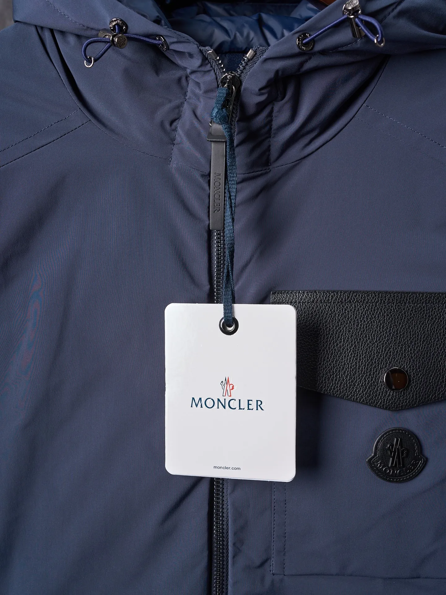 P860 Actual hanging auction] MONCLER/Maskled Leather Flap Pocket Logo Jacket Style Hooded Down Jacket [Ready Stock] 1 2 3 4 Made of 90 white duck down with a weight of 200g to ensure excellent thermal insulation performance. After strict screening and processing, the velvet is not easy to drill, ensuring durability. After selecting 100% polyester fiber and undergoing microfiberization treatment, the individual fibers become extremely fine, which greatly increases the fiber surface area, making the fabric soft, smooth, and close to natural fibers in touch. The high-density textile method makes the structure tight, thus giving it a certain degree of wrinkle resistance, windproof warmth and wear resistance.   The high-density lining is woven with ultra-fine denier, with a thickness of 0.08mm to avoid increasing the overall weight and making it smooth to wear. The high-density woven structure forms a wind resistance layer to protect the thermal efficiency of the thermal layer from loss. It can also withstand the expansion pressure of down and prevent deformation and damage after long-term use.  The leather flap pocket on the chest is matched with a pebbled leather flap + matte metal buckle, which is low-key yet exuding elegance. The hidden adjustment rope adds a sense of sophistication to your hands. The "ID card" is directly embedded on the black satin inner patch pocket! Silver snaps + red, white and blue webbing, low-key yet exuding a sense of luxury, both visually and tactilely smooth.