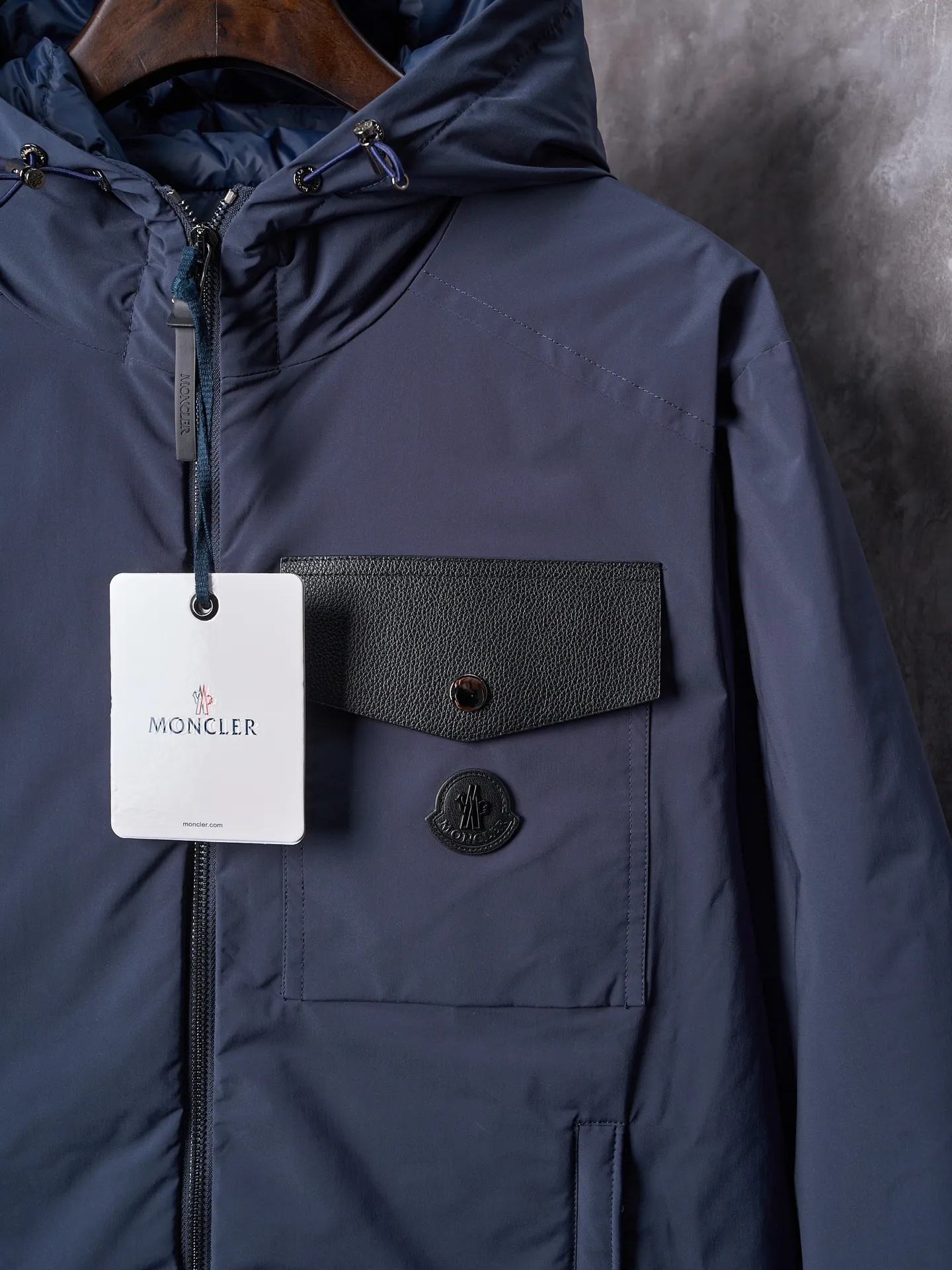 P860 Actual hanging auction] MONCLER/Maskled Leather Flap Pocket Logo Jacket Style Hooded Down Jacket [Ready Stock] 1 2 3 4 Made of 90 white duck down with a weight of 200g to ensure excellent thermal insulation performance. After strict screening and processing, the velvet is not easy to drill, ensuring durability. After selecting 100% polyester fiber and undergoing microfiberization treatment, the individual fibers become extremely fine, which greatly increases the fiber surface area, making the fabric soft, smooth, and close to natural fibers in touch. The high-density textile method makes the structure tight, thus giving it a certain degree of wrinkle resistance, windproof warmth and wear resistance.   The high-density lining is woven with ultra-fine denier, with a thickness of 0.08mm to avoid increasing the overall weight and making it smooth to wear. The high-density woven structure forms a wind resistance layer to protect the thermal efficiency of the thermal layer from loss. It can also withstand the expansion pressure of down and prevent deformation and damage after long-term use.  The leather flap pocket on the chest is matched with a pebbled leather flap + matte metal buckle, which is low-key yet exuding elegance. The hidden adjustment rope adds a sense of sophistication to your hands. The "ID card" is directly embedded on the black satin inner patch pocket! Silver snaps + red, white and blue webbing, low-key yet exuding a sense of luxury, both visually and tactilely smooth.