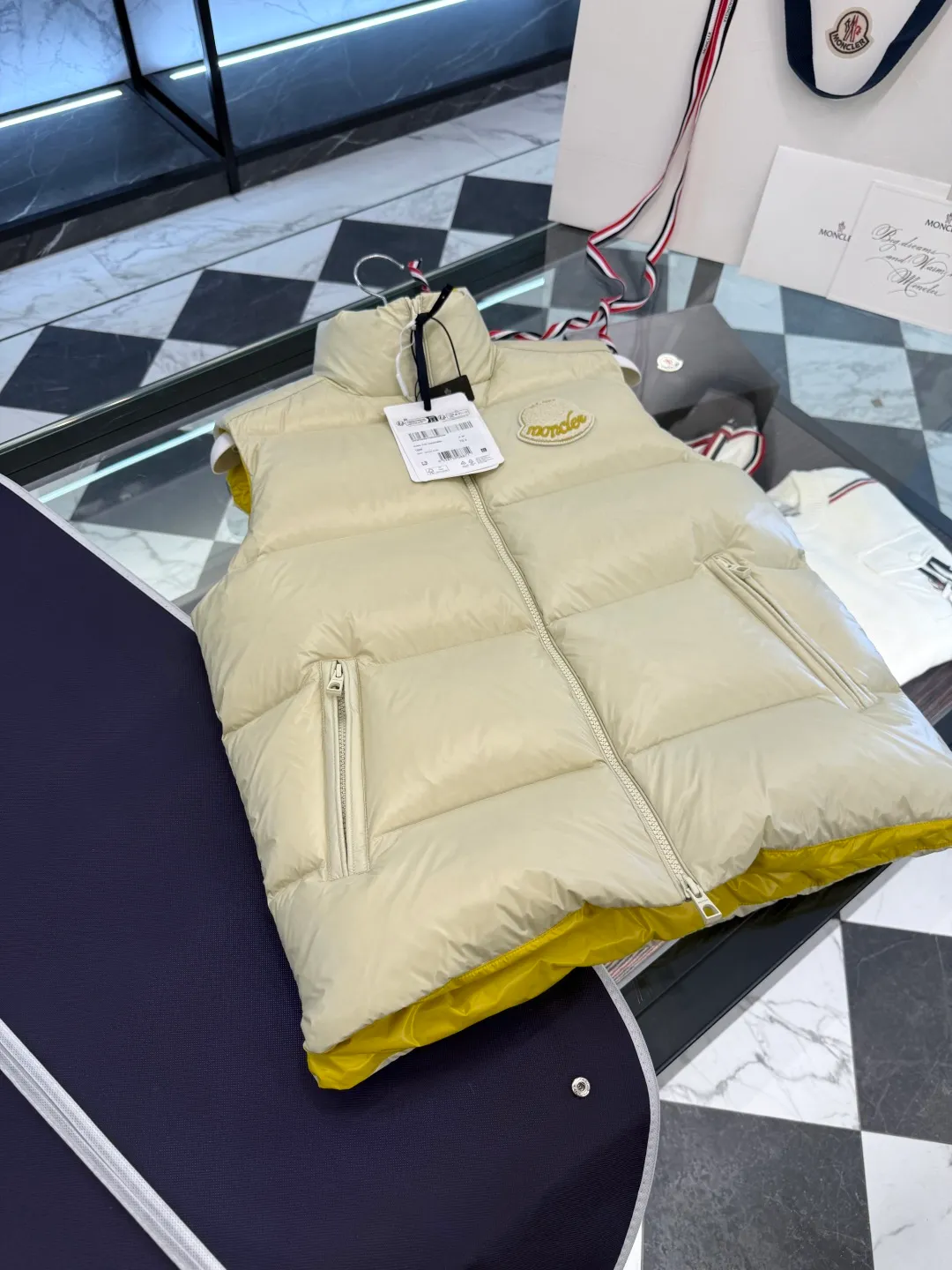 P660 Moncler Lipsi down vest. Contrast color splicing design. Super full filling. Lipsi men's down vest is made of shiny nylon laqué fabric, suitable for wearing in different seasons, bringing warmth and care.  The Lipsi short down vest embodies Moncler's classic design and is a must-have item for your wardrobe from season to season. Crafted from lightweight, functional nylon laqué fabric, it has a contrast lining for a vibrant feel. Details •Made from lightweight nylon laqué fabric •Lightweight nylon laqué lining •Filled with down •Stand-up collar •Zipper closure •Zip pockets •Chenille logo patch Size: 1-5 Black/Ivory Couple Style