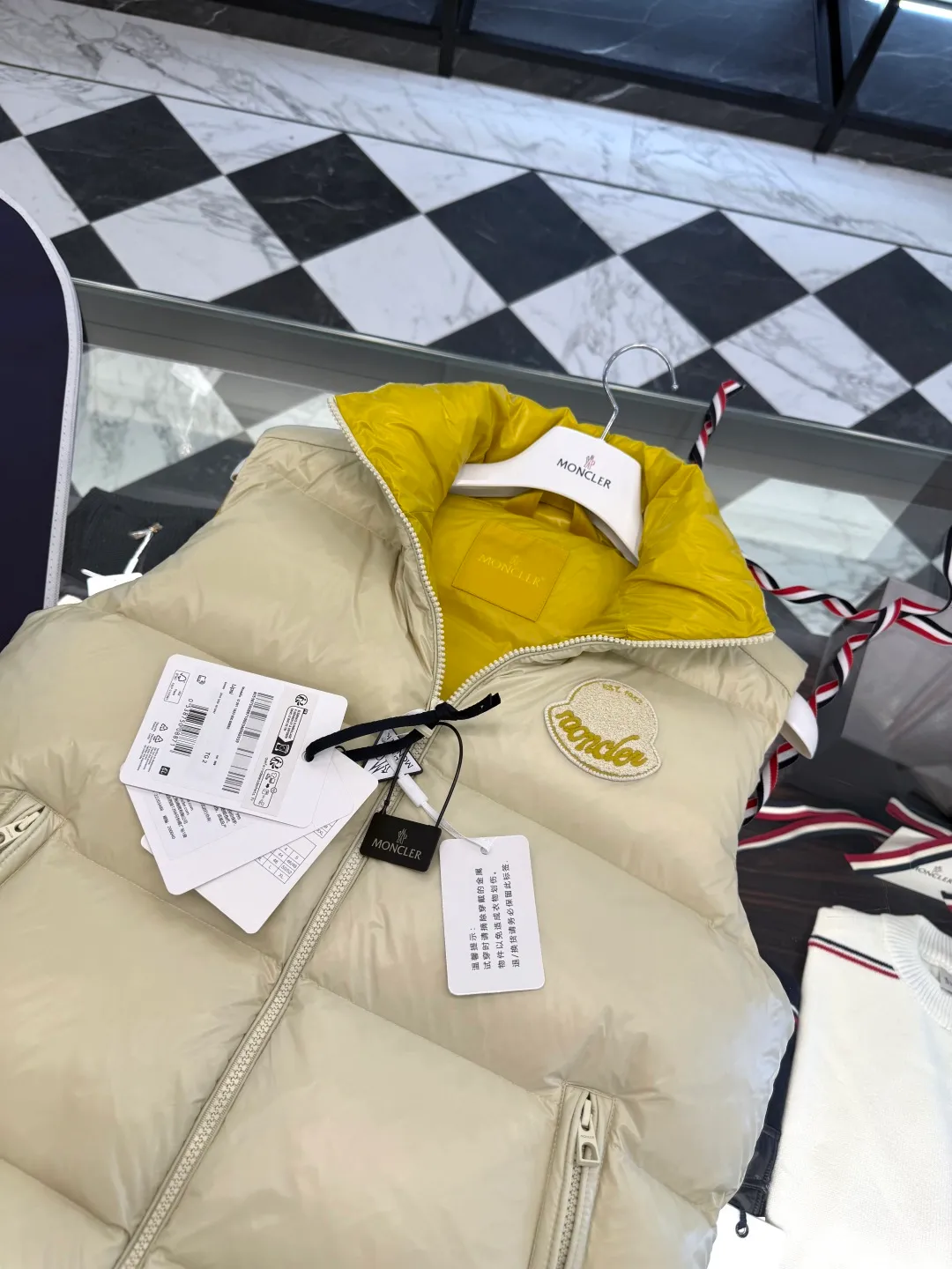 P660 Moncler Lipsi down vest. Contrast color splicing design. Super full filling. Lipsi men's down vest is made of shiny nylon laqué fabric, suitable for wearing in different seasons, bringing warmth and care.  The Lipsi short down vest embodies Moncler's classic design and is a must-have item for your wardrobe from season to season. Crafted from lightweight, functional nylon laqué fabric, it has a contrast lining for a vibrant feel. Details •Made from lightweight nylon laqué fabric •Lightweight nylon laqué lining •Filled with down •Stand-up collar •Zipper closure •Zip pockets •Chenille logo patch Size: 1-5 Black/Ivory Couple Style