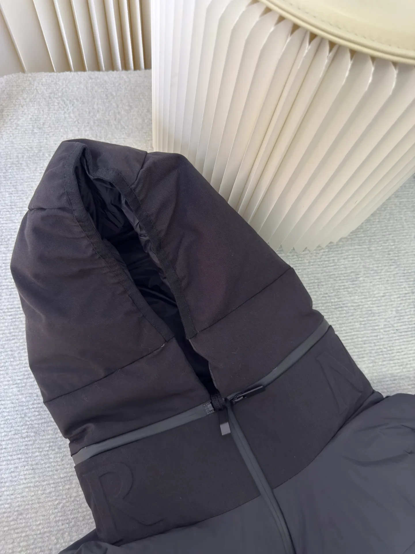 P660 MONCLER Badge Hooded Down Vest is made of nylon fabric made of 100% nylon. It is woven into a tight and tough fabric through advanced textile technology. It improves the strength of the frame and effectively blocks the invasion of cold wind and locks in the warm air generated by the down layer. After tight weaving and special treatment, it is waterproof and windproof. The surface forms a certain lotus leaf effect. It is also wrinkle-resistant and not easy to deform, making it easy for daily care.  The quilting stitches are sewn in a diagonal direction at an angle of about 70 degrees, and the diagonal lines are arranged in parallel. The fabric and filling are planned into different functional areas, and the quilting stitches in each partition are relatively independent. This allows the finished product to produce a larger deformation space along the diagonal direction when stretched and pressed, making it less likely to tighten and break, and has rich visual effects, modern and advanced features.  After the hood is removed, the stand-up collar displays an embossed logo of the same color, adding a unique visual experience and tactile details. High-quality filling: It is filled with 90% selected white duck down, weighing 170g, ensuring fluffy rebound, lightness and warmth. Size 1 2 3 4