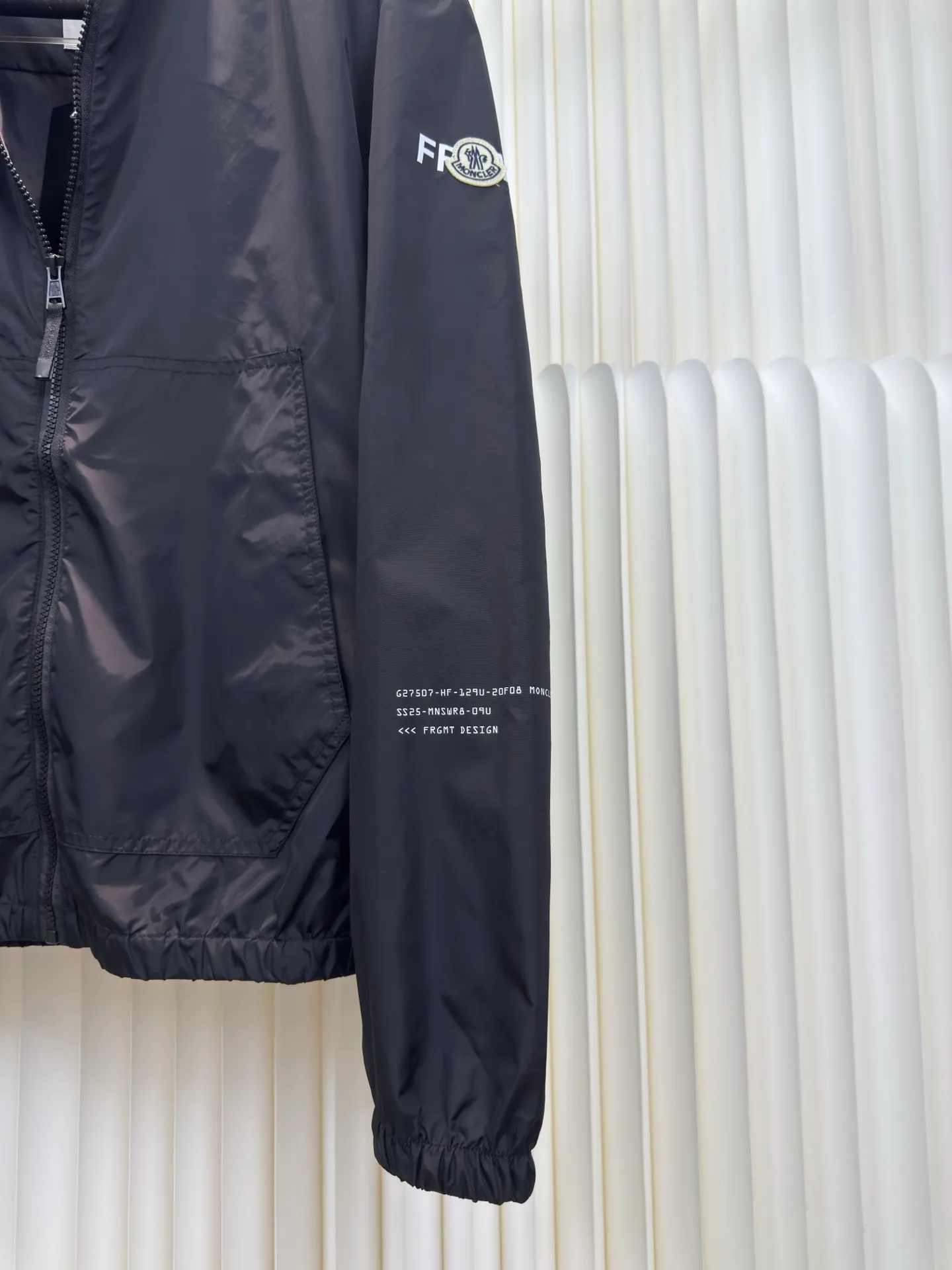 P530 Moncler Hiroshi Fujiwara co-branded bomber jacket is a coated nylon canvas fabric formed after nylon base material and coating treatment. The coating can effectively block moisture penetration, making it very waterproof. The nylon itself has high wear resistance. The ribbed knitted cotton collar and the cool luster of the coated nylon form a visual and physical contrast. The cotton ribbing is warm and skin-friendly, durable and not easily deformed after being washed. The zipper opens and closes, and a strap is attached to the zipper head to make it easier to open and close clothing. There are patch pockets on the left and right sides, and the edges of the pockets are reinforced with double-needle sewing technology, which is strong and beautiful at the same time. The cuffs and hem are closed with flat ribs to ensure no binding, ensuring wind resistance and warmth, and not easily deformed.  Screen glue printing. During the printing process of glue printing, the glue will form a thick colloid layer, making the printed pattern have a three-dimensional effect. It not only enhances the visual effect of printing, but also makes the hand feel richer. After the glue printing is cured, the printed pattern is closely integrated with the fabric and is not easy to fall off or wear. Size: 1 2 3 4
