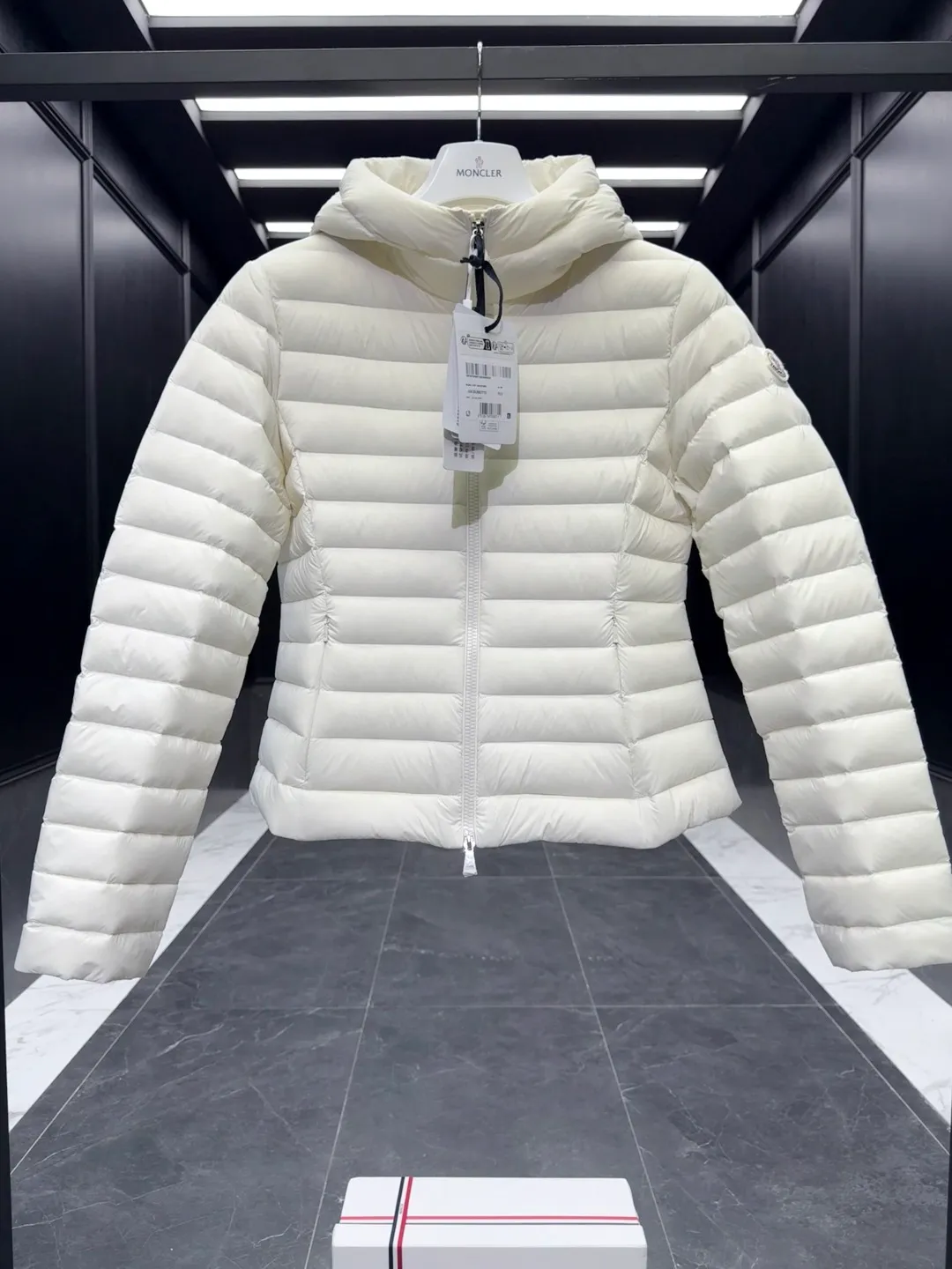 P700 Premium down⬆️Moncler. New Ige hooded short down jacket for women. Ige hooded short down jacket. The Ige down jacket is made of longue saison fabric and is suitable for mild weather. This nylon fabric is warm without being bulky. Designed in a cropped silhouette, it features a classic hooded silhouette and a cinched waist for a smooth, feminine look. It is recommended to choose one size up.  • Made of longuesaison fabric • Longuesaison lining • Filled with down • Hood • Zipper closure • Zippered pocket Size: 1-4 Ivory/Black D00700