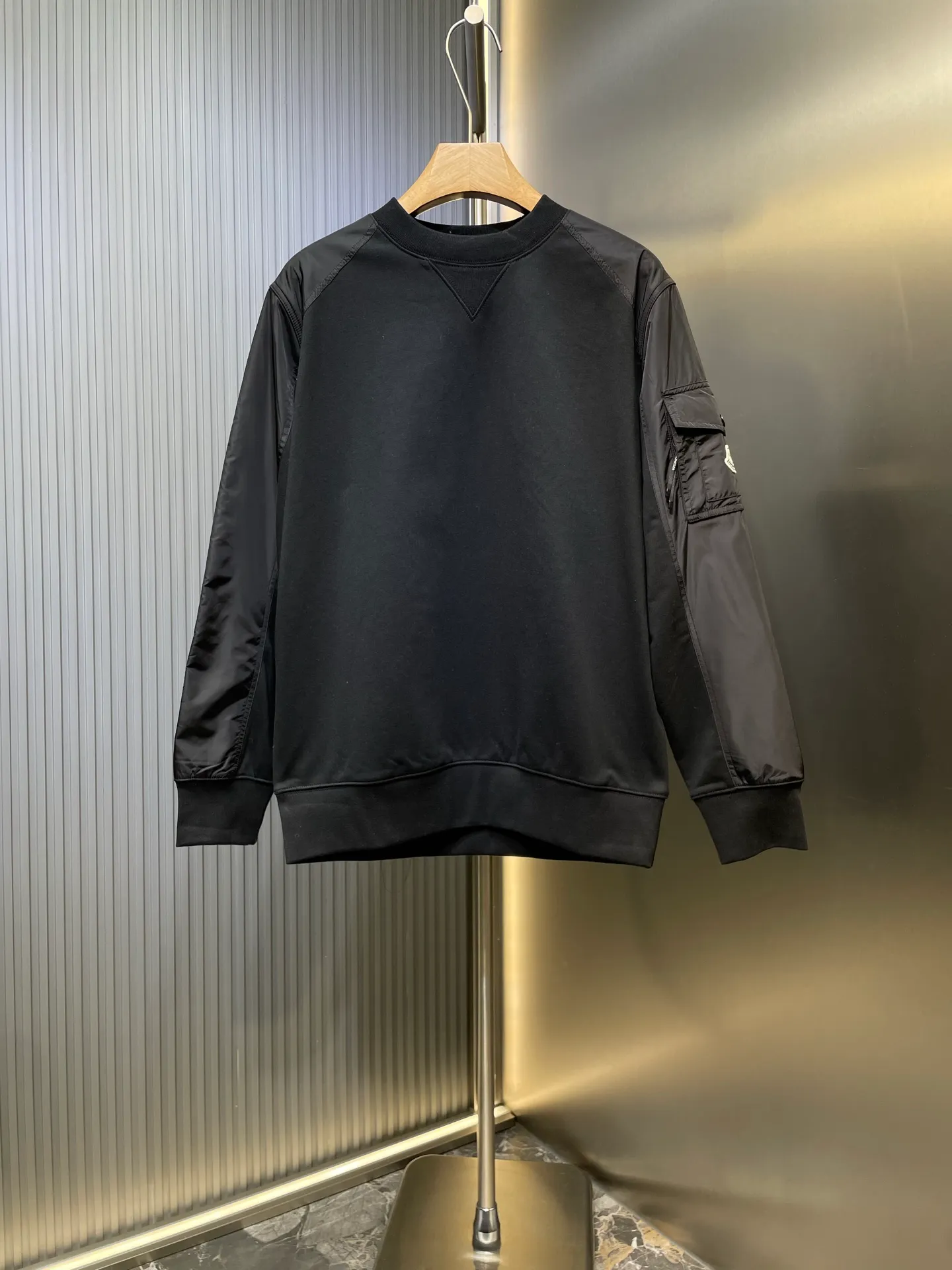 P410 Moncler 🌟Logo patch pocket splicing sweatshirt. Customized soft velvet cotton blend warm core material and tough nylon high-density woven material. Smooth and delicate, comfortable and close to the skin. With a touch of deep black as the base, the chest quietly draws a triangular world. The iconic Moncler logo embroidered logo decorates the sleeves. Integrated nylon fabrics embellish the square silhouette. Cross-field aesthetic grafting. Exquisite small pocket design reveals a flexible and relaxed beauty. Deconstruct the attitude of the modern gentleman and show his taste in silence. Process 1: Needle and shuttle stitching technology can make full use of the respective advantages of knitted fabrics and woven fabrics. By choosing the appropriate sewing process and stitches, the splicing parts can be ensured to be strong and beautiful. Process 2: Template machine bag opening. The preset template guides the position, shape and size of the bag opening. The accuracy ensures the quality of the bag opening effect. Process 3: The fabrics are washed and have a better hand texture. It is not easy to deform and shrink. Not easy to fade and maintain long-lasting beauty Accessories: Customized 1:1 Moncler embroidered logo Customized 1:1 Moncler zipper Customized 1:1 Moncler drawstring Customized 1:1 Moncler snap button Customized 1:1 Moncler trademark Version: Loose version Size: S M L XL