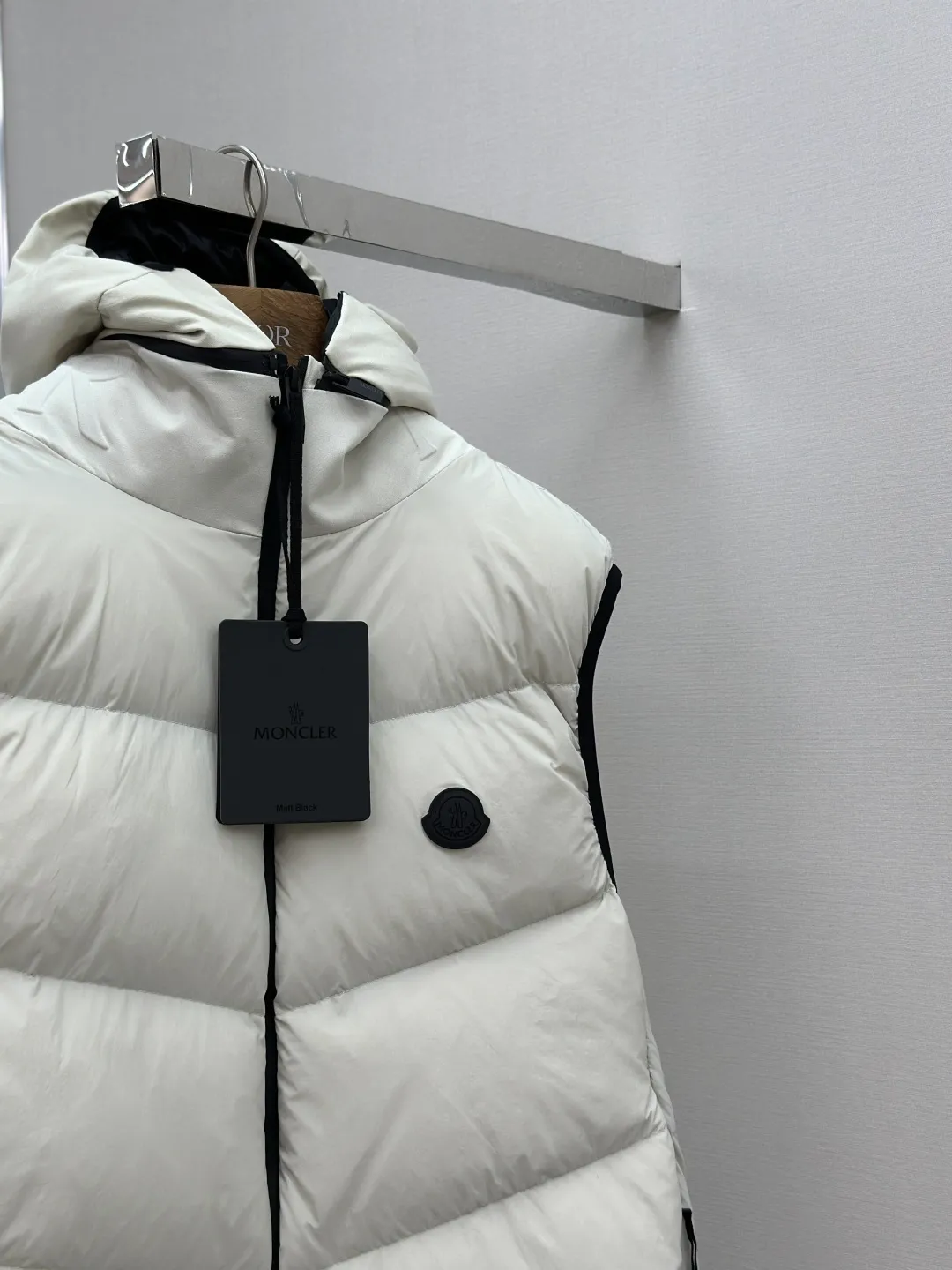 P660 MONCLER Badge Hooded Down Vest Fabric selection: Made of nylon fabric made of 100% nylon, which is woven into a tight and tough fabric through advanced textile technology. It improves the strength of the skeleton to effectively block the invasion of cold wind and lock the warm air generated by the down layer. After tight weaving and special treatment, it has waterproof and windproof functions. The surface forms a certain lotus leaf effect, and is wrinkle-resistant and not easily deformed, making it easy for daily care.  Technology: The quilting stitches are sewn in a diagonal direction at an angle of approximately 70 degrees. The diagonal lines are arranged in parallel. The fabric and filling are planned into different functional areas, and the quilting stitches in each partition are relatively independent. This allows the finished product to produce a larger deformation space along the diagonal direction when stretched and pressed, making it less likely to tighten and break, and has rich visual effects, modern and advanced features.  Details: After the hood is removed, the stand-up collar displays an embossed logo of the same color, adding a unique visual experience and tactile details.  High-quality filling: It is filled with 90% selected white duck down, weighing 170g, ensuring fluffy rebound, lightness and warmth.  Accessories: One-to-one customized zipper pendant, one-to-one customized badge, one-to-one customized three-label SIZE: 1 2 3 4