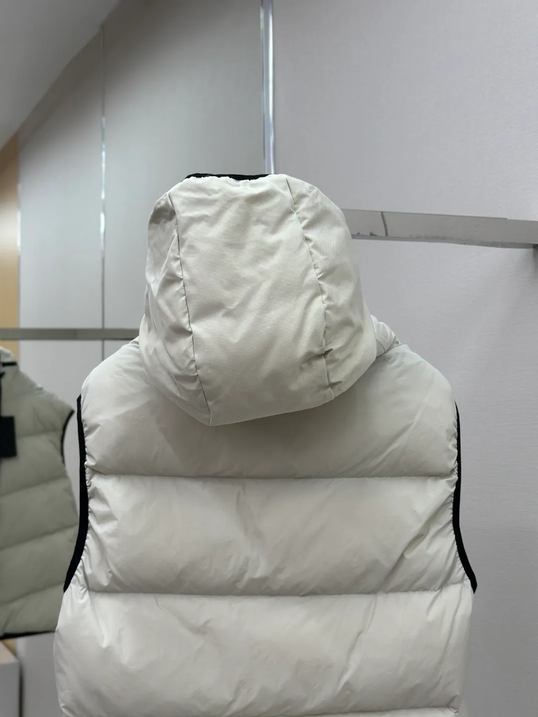 P660 MONCLER Badge Hooded Down Vest Fabric selection: Made of nylon fabric made of 100% nylon, which is woven into a tight and tough fabric through advanced textile technology. It improves the strength of the skeleton to effectively block the invasion of cold wind and lock the warm air generated by the down layer. After tight weaving and special treatment, it has waterproof and windproof functions. The surface forms a certain lotus leaf effect, and is wrinkle-resistant and not easily deformed, making it easy for daily care.  Technology: The quilting stitches are sewn in a diagonal direction at an angle of approximately 70 degrees. The diagonal lines are arranged in parallel. The fabric and filling are planned into different functional areas, and the quilting stitches in each partition are relatively independent. This allows the finished product to produce a larger deformation space along the diagonal direction when stretched and pressed, making it less likely to tighten and break, and has rich visual effects, modern and advanced features.  Details: After the hood is removed, the stand-up collar displays an embossed logo of the same color, adding a unique visual experience and tactile details.  High-quality filling: It is filled with 90% selected white duck down, weighing 170g, ensuring fluffy rebound, lightness and warmth.  Accessories: One-to-one customized zipper pendant, one-to-one customized badge, one-to-one customized three-label SIZE: 1 2 3 4