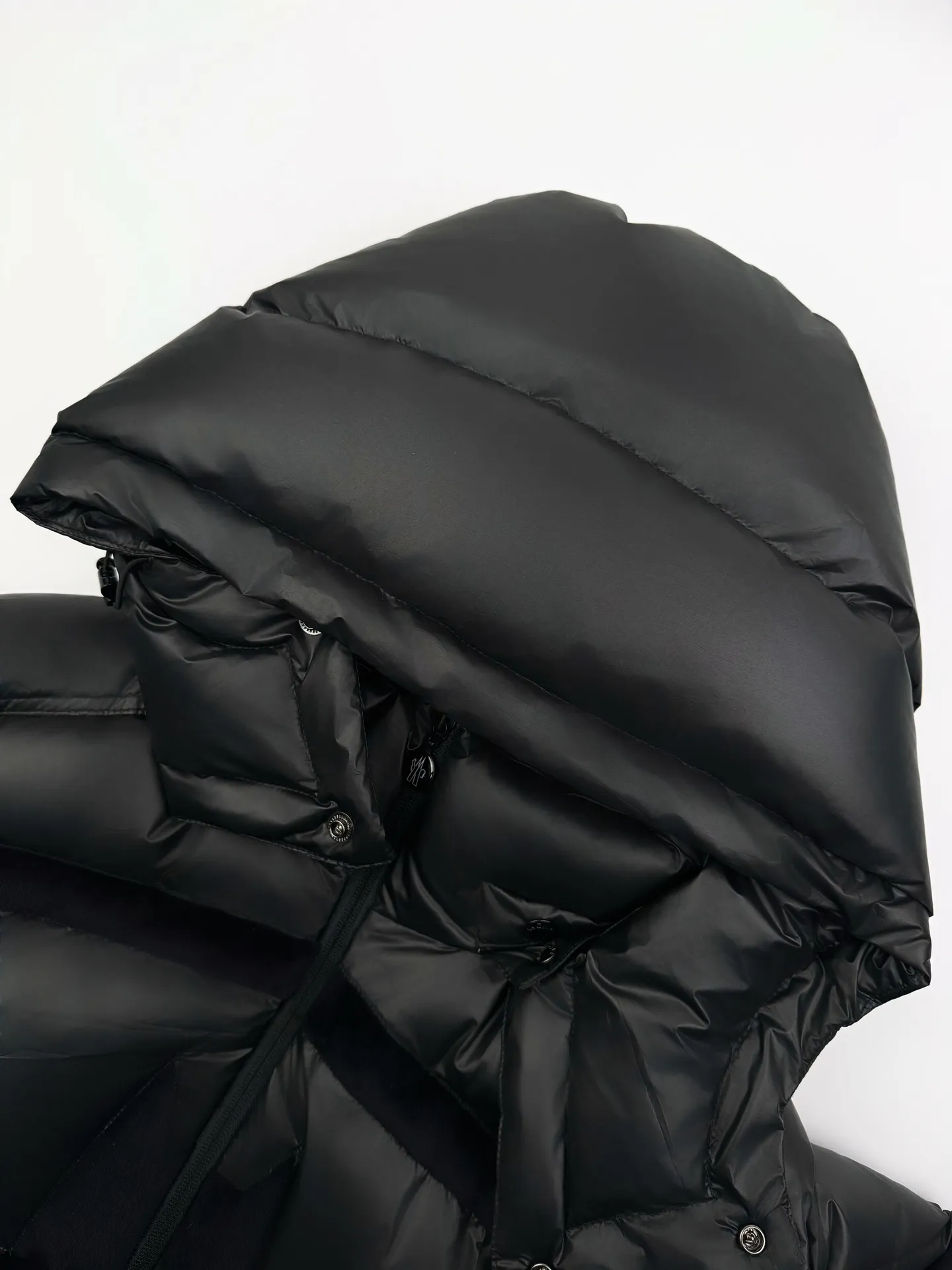 P1260 Moncler Batman Logo Down Jacket Customized black premium carbon black coated windbreaker fabric Customized Korean trendy velvet knitted fabric Made of 400D calendered bile fabric National standard 95 white goose down (welcome to test) Full of down content Warmth and light fluffy Craftsmanship to create a joint series Decorated with the Batman logo on the front Inspired by the famous superhero High degree of recognition The iconic Moncler embroidered logo is present on the sleeves It highlights the brand style and pays tribute to the classics. It is also an interpretation of modern fashion. It tightly locks in body temperature and enjoys warmth and comfort. It becomes the most intimate companion in winter. Process 1: Computer laser burning and cutting. It uses a high-energy laser beam to instantly melt the fabric fibers at high temperature. Precise cutting and engraving on the fabric according to the original pattern. The edges are flat to achieve seamless splicing. It effectively prevents the penetration of cold wind and improves the thermal insulation performance of the down jacket. Process 2: Computer mechanical down filling. Priority is given to making the inner liner pattern to determine the down filling area according to the original three-dimensional effect to determine the gram weight of down per square meter, thereby calculating the filling amount of each cut piece. The computer down filling machine uses a digital weighing unit to achieve stable measurement. Process 3: Computer template machine line running process. The line running process of the computer template machine shows extremely high neatness and smoothness. The craftsman accurately controls the size during the operation to ensure that each row line meets the design requirements. The lines of the entire template are smooth and unified, clean and beautiful. Paving: Customized 1:1 Moncler snap button Customized 1:1 Moncler zipper Customized 1:1 Moncler adjustment buckle Customized 1:1 Moncler pendant Customized 1:1 Moncler machine eye Customized 1:1 Moncler embroidered logo Customized 1:1 Moncler trademark Function: Detachable and adjustable hood. Match as you like Size: 1 code 2 codes 3 codes 4 codes 5 codes 6 codes