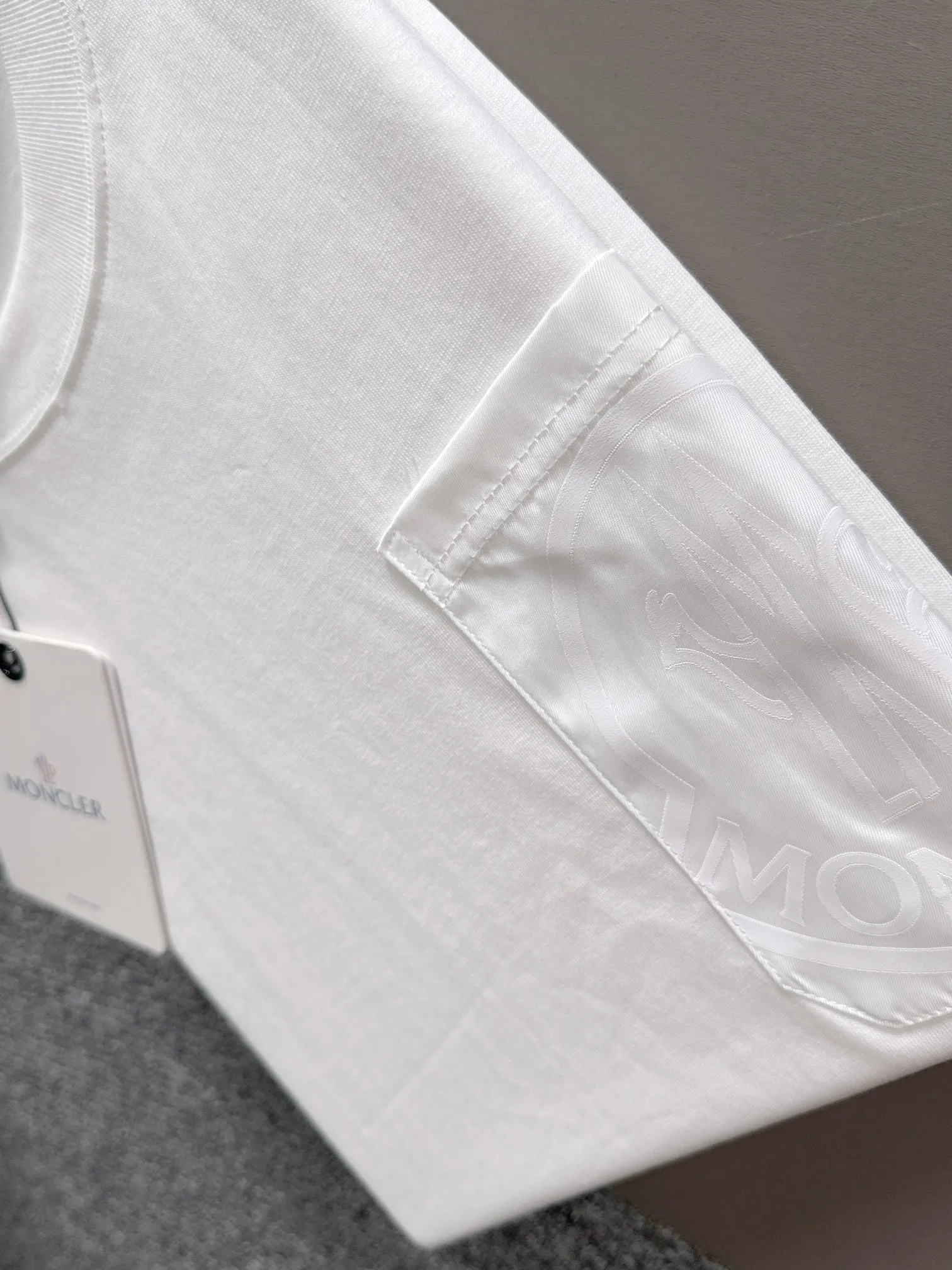 P160 Moncler 2025 new model Woven pocket splicing Hollow embroidered letter logo Uniform short-sleeved T-shirt for men and women ·Customized 260g 100% double yarn pure cotton fabric ·Dyeing 32 counts double-strand thread ·Collar label, hangtag, main mark and three labels complete Color: White Size: XS S M L