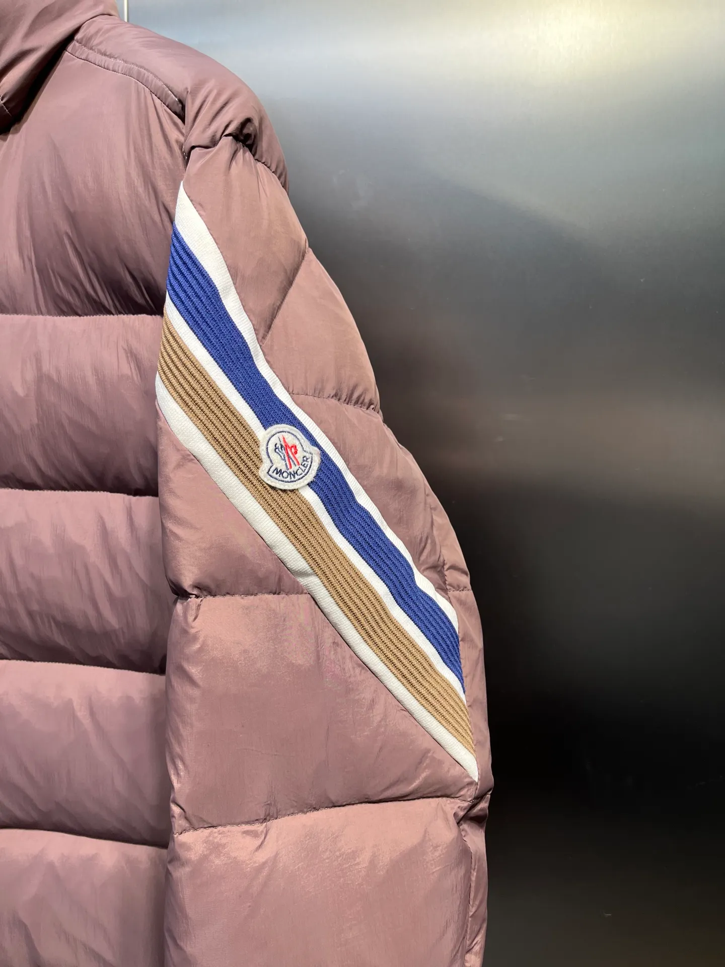 P840 Moncler Solayan men's tri-color trim short down jacket. Filled with premium goose down. The finest, lightest and neatest fabric. Solayan men's short down jacket is decorated with the season's signature stripe details, blending sporty spirit with timeless style. The Solayan down jacket is made of micro chic fabric and has a tough square shape design, highlighting Moncler's sporty spirit. This cropped down jacket features tricolor stripes on the sleeves, a seasonal take on the brand's signature. Comes with a practical pull-out hood. Details •Made from micro chic nylon fabric •Micro chic nylon lining •Down filled •Pull-out hood •Zip closure •Zip pockets •Adjustable cuffs •Elastic drawstring hem •Tri-color trim on sleeves Size: 1-5 Color: White Dark Brown Black