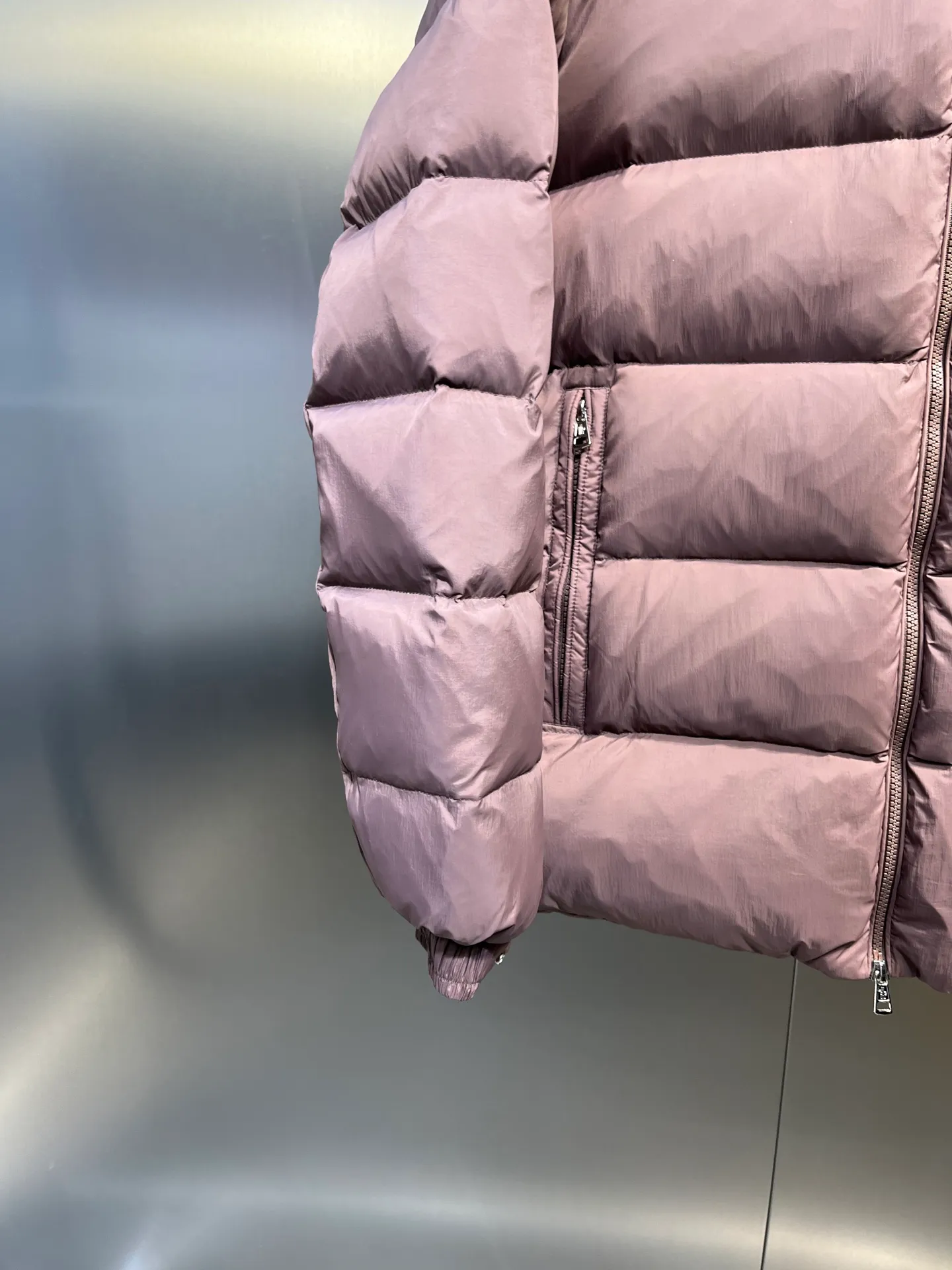 P840 Moncler Solayan men's tri-color trim short down jacket. Filled with premium goose down. The finest, lightest and neatest fabric. Solayan men's short down jacket is decorated with the season's signature stripe details, blending sporty spirit with timeless style. The Solayan down jacket is made of micro chic fabric and has a tough square shape design, highlighting Moncler's sporty spirit. This cropped down jacket features tricolor stripes on the sleeves, a seasonal take on the brand's signature. Comes with a practical pull-out hood. Details •Made from micro chic nylon fabric •Micro chic nylon lining •Down filled •Pull-out hood •Zip closure •Zip pockets •Adjustable cuffs •Elastic drawstring hem •Tri-color trim on sleeves Size: 1-5 Color: White Dark Brown Black