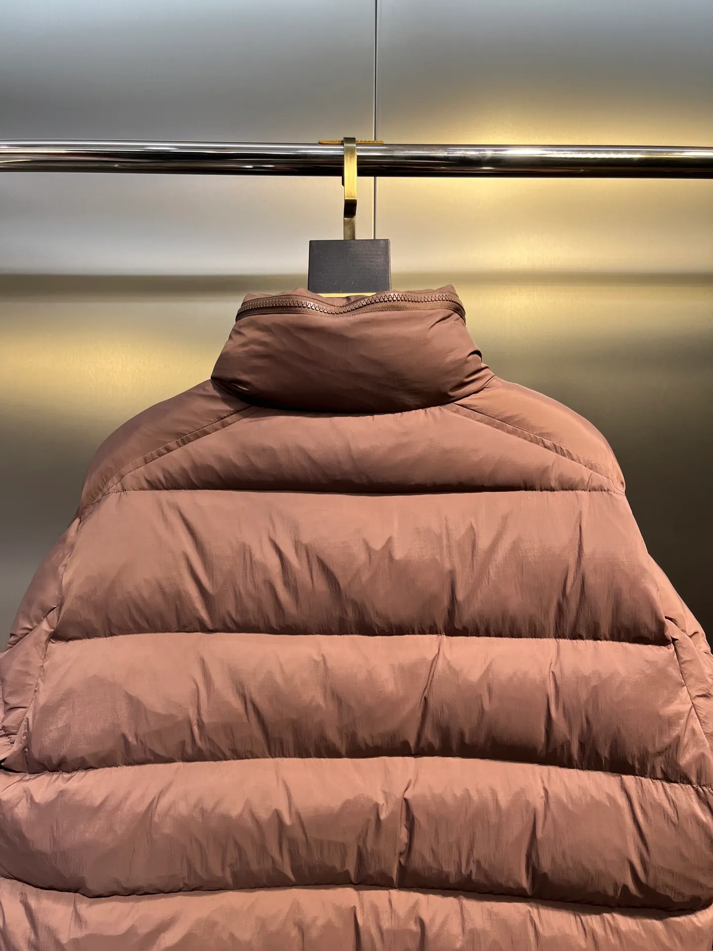 P840 Moncler Solayan men's tri-color trim short down jacket. Filled with premium goose down. The finest, lightest and neatest fabric. Solayan men's short down jacket is decorated with the season's signature stripe details, blending sporty spirit with timeless style. The Solayan down jacket is made of micro chic fabric and has a tough square shape design, highlighting Moncler's sporty spirit. This cropped down jacket features tricolor stripes on the sleeves, a seasonal take on the brand's signature. Comes with a practical pull-out hood. Details •Made from micro chic nylon fabric •Micro chic nylon lining •Down filled •Pull-out hood •Zip closure •Zip pockets •Adjustable cuffs •Elastic drawstring hem •Tri-color trim on sleeves Size: 1-5 Color: White Dark Brown Black