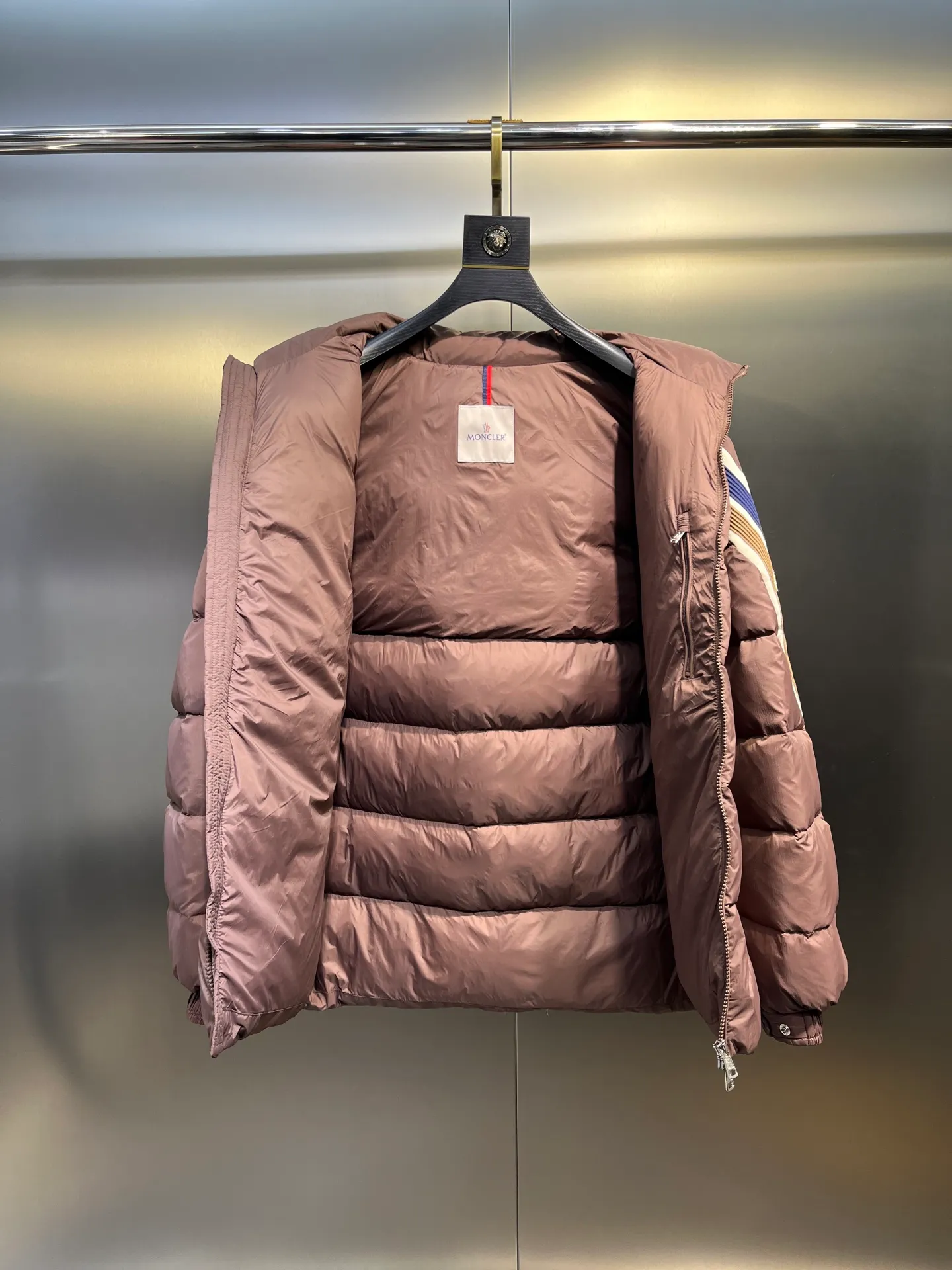 P840 Moncler Solayan men's tri-color trim short down jacket. Filled with premium goose down. The finest, lightest and neatest fabric. Solayan men's short down jacket is decorated with the season's signature stripe details, blending sporty spirit with timeless style. The Solayan down jacket is made of micro chic fabric and has a tough square shape design, highlighting Moncler's sporty spirit. This cropped down jacket features tricolor stripes on the sleeves, a seasonal take on the brand's signature. Comes with a practical pull-out hood. Details •Made from micro chic nylon fabric •Micro chic nylon lining •Down filled •Pull-out hood •Zip closure •Zip pockets •Adjustable cuffs •Elastic drawstring hem •Tri-color trim on sleeves Size: 1-5 Color: White Dark Brown Black