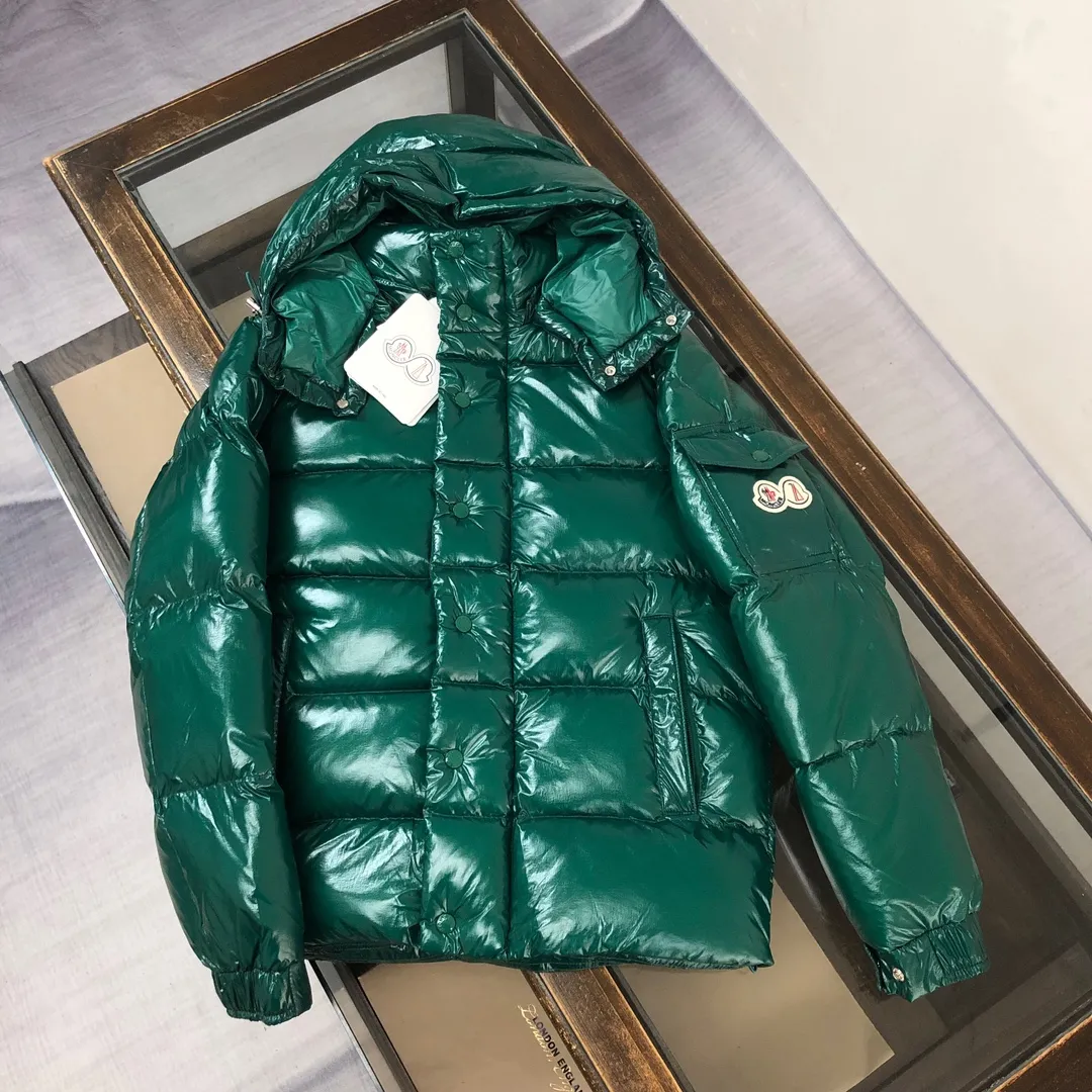 P800 Moncler Maya 70 Short Down Jacket Forest Green The iconic men's Moncler Maya 70 down jacket is highly recognizable and specially designed to celebrate the brand's 70th anniversary. The Moncler Maya down jacket has been reinterpreted specifically to celebrate Moncler's 70th anniversary, and the iconic silhouette has been refreshed in new colors. A classic example of the brand's DNA, it's made from shiny lacquered nylon and embellished with signature rectangular quilting. A classic, cropped design that spans seasons and fashions, the removable hood features a statement silhouette, removable hood and adjustable hem. The sleeves are decorated with the brand's signature classic patch pockets and a patchwork logo designed to celebrate the 70th anniversary. Color: black, ivory white, basalt gray, purple, cabin brown, forest green, code number: 1-2-3-4-5 (M～3xl)