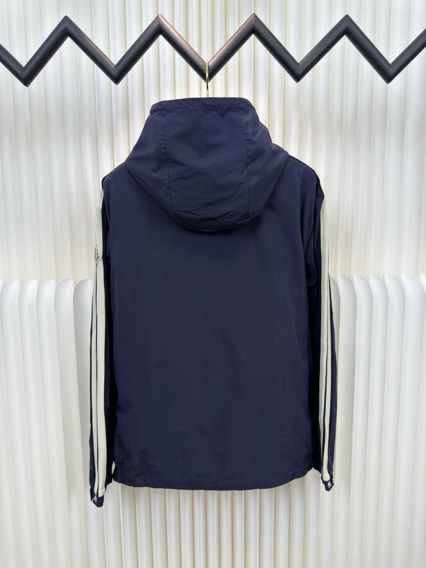 P570 MONCLER lightweight jacket with web trim at the mouth is made of 100% polyester fiber to create a tough protective outer layer. It is famous for its excellent tear resistance and wear resistance. It can quickly return to flatness during wearing and maintain the crisp and stylish appearance of the clothing for a long time. At the same time, it is not easy to deform after being washed for a long time.  Decorative edging in two different colors has been added to the center section of the sleeves. This design element not only adds visual highlights to clothing, making it more fashionable and unique. The webbing is precisely positioned along the cuffs to the seam of the collar and hat to ensure symmetry and overall smoothness. Before actual sewing, use very fine basting stitches for pre-fixing. This step is crucial to prevent the webbing from slipping, twisting, or wrinkling during sewing and ensuring that the final stitch is straight and perfect. Size 1 2 3 4