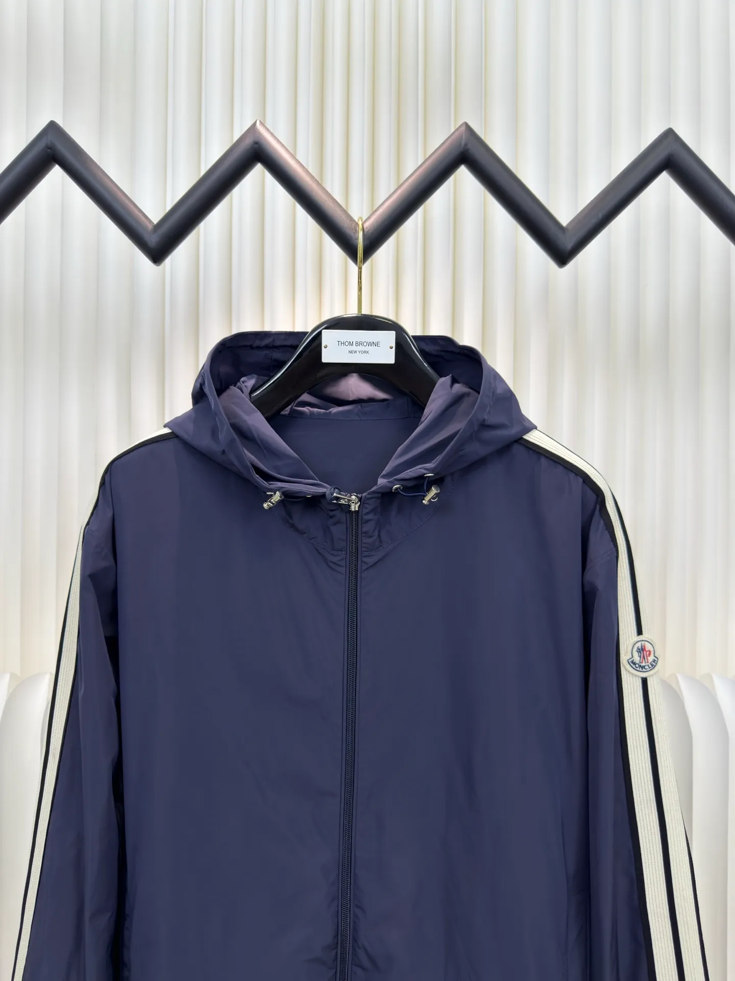 P570 MONCLER lightweight jacket with web trim at the mouth is made of 100% polyester fiber to create a tough protective outer layer. It is famous for its excellent tear resistance and wear resistance. It can quickly return to flatness during wearing and maintain the crisp and stylish appearance of the clothing for a long time. At the same time, it is not easy to deform after being washed for a long time.  Decorative edging in two different colors has been added to the center section of the sleeves. This design element not only adds visual highlights to clothing, making it more fashionable and unique. The webbing is precisely positioned along the cuffs to the seam of the collar and hat to ensure symmetry and overall smoothness. Before actual sewing, use very fine basting stitches for pre-fixing. This step is crucial to prevent the webbing from slipping, twisting, or wrinkling during sewing and ensuring that the final stitch is straight and perfect. Size 1 2 3 4